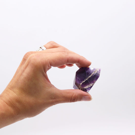 Cristal de amatista morado con veta dorada, corte elegante, ideal para decoración o colección.