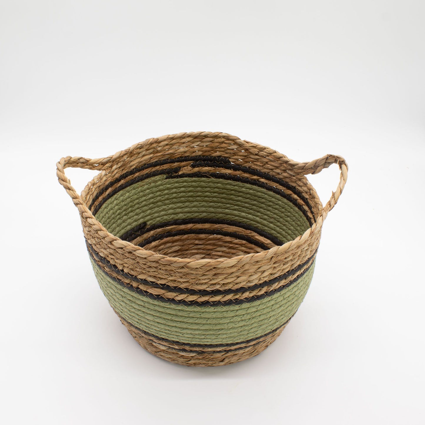 Cesta redonda tejida en pasto marino y algodón, con franjas naturales, verdes y negras, y dos asas laterales.