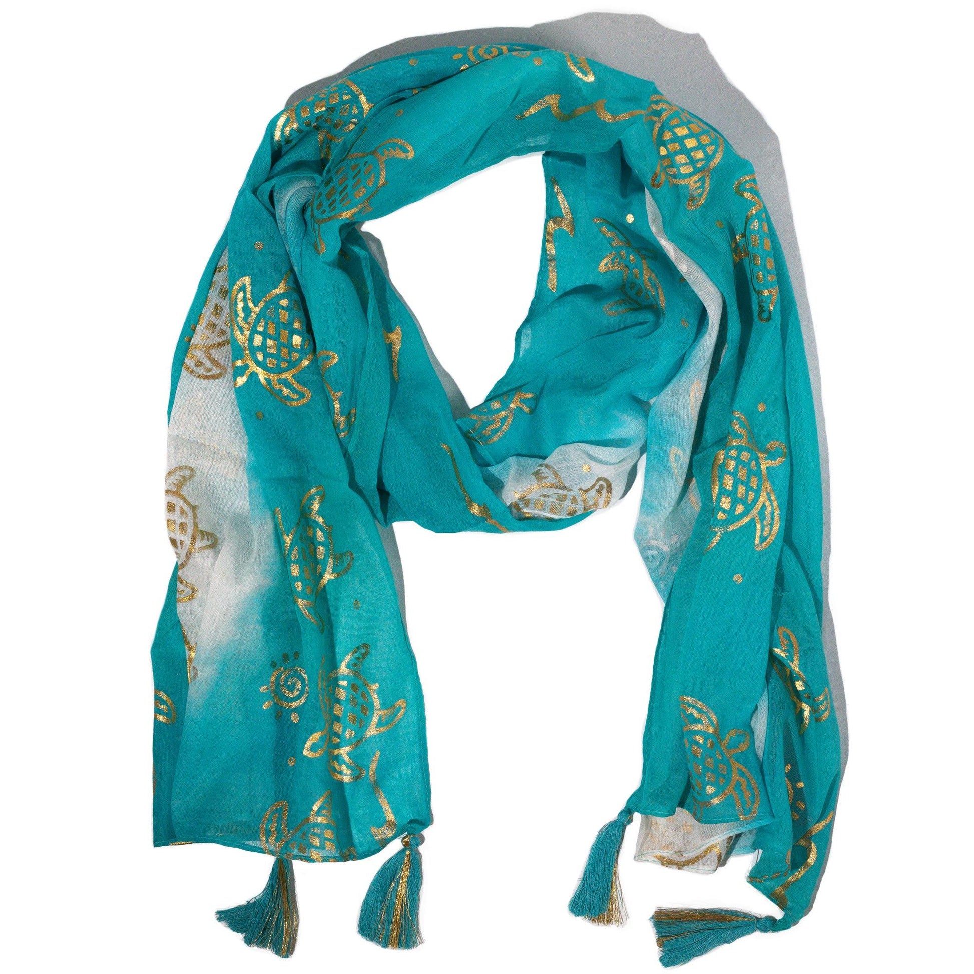 Bufanda turquesa de gasa con estampado de tortugas doradas y flecos, ideal para un look veraniego y fresco.
