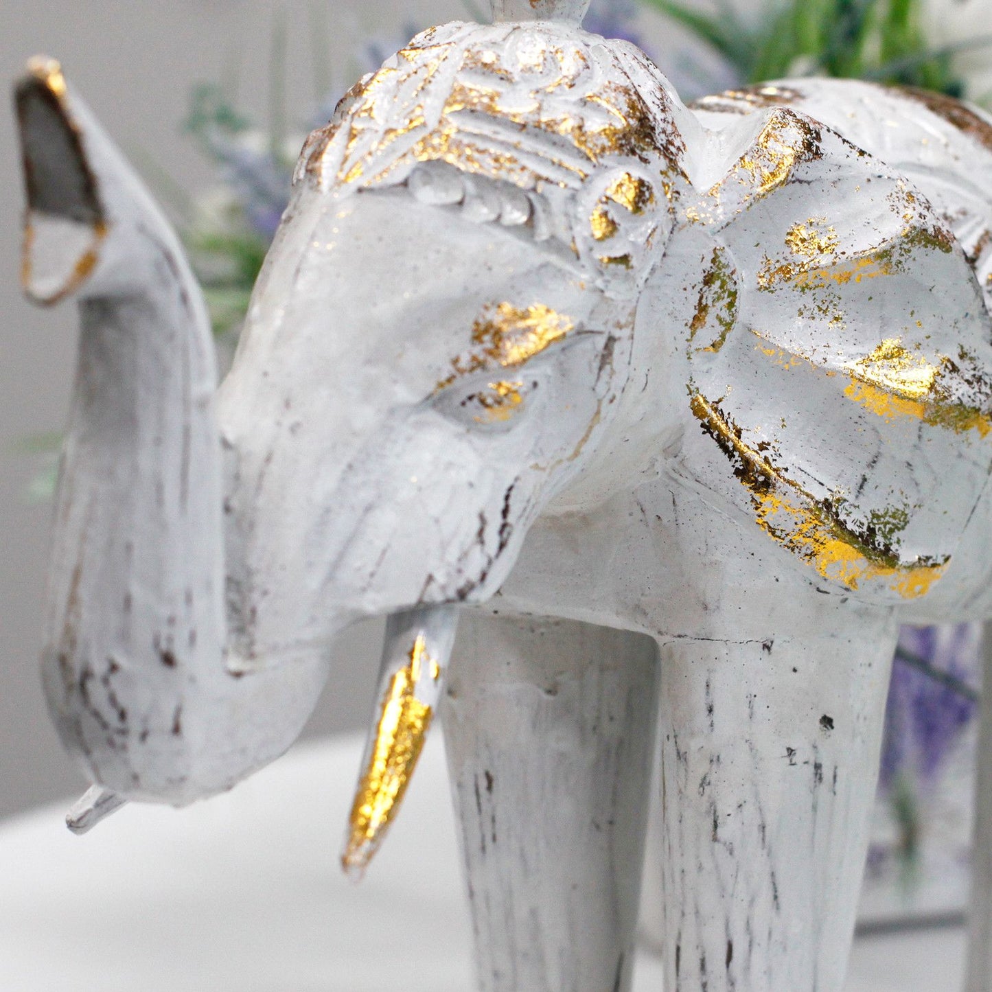 Elefante decorativo blanco con detalles dorados, estilo vintage, ideal para decoración de interiores.