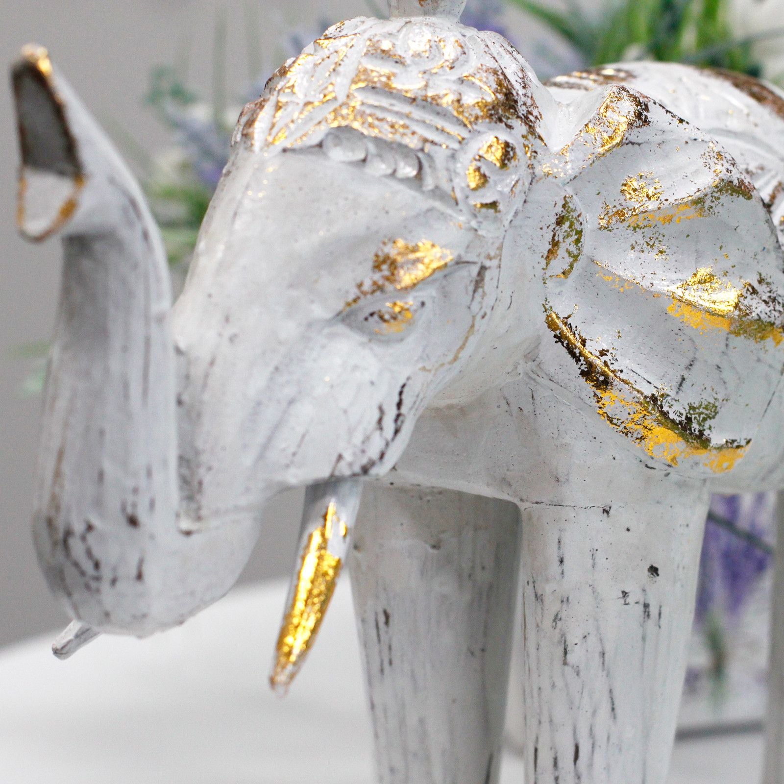 Elefante decorativo blanco con detalles dorados, estilo vintage, ideal para decoración de interiores.