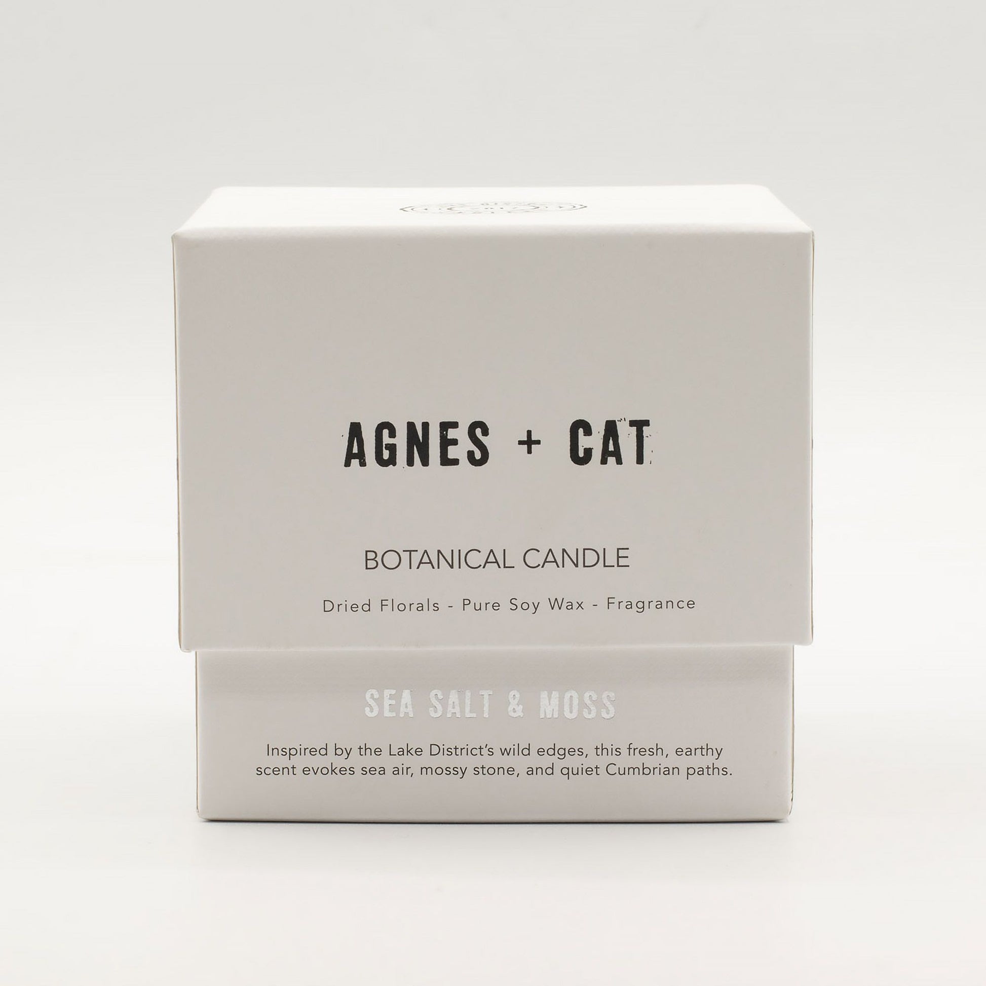 Vela botánica Agnes + Cat, cera de soja, fragancia sal marina y musgo, caja blanca con diseño minimalista.