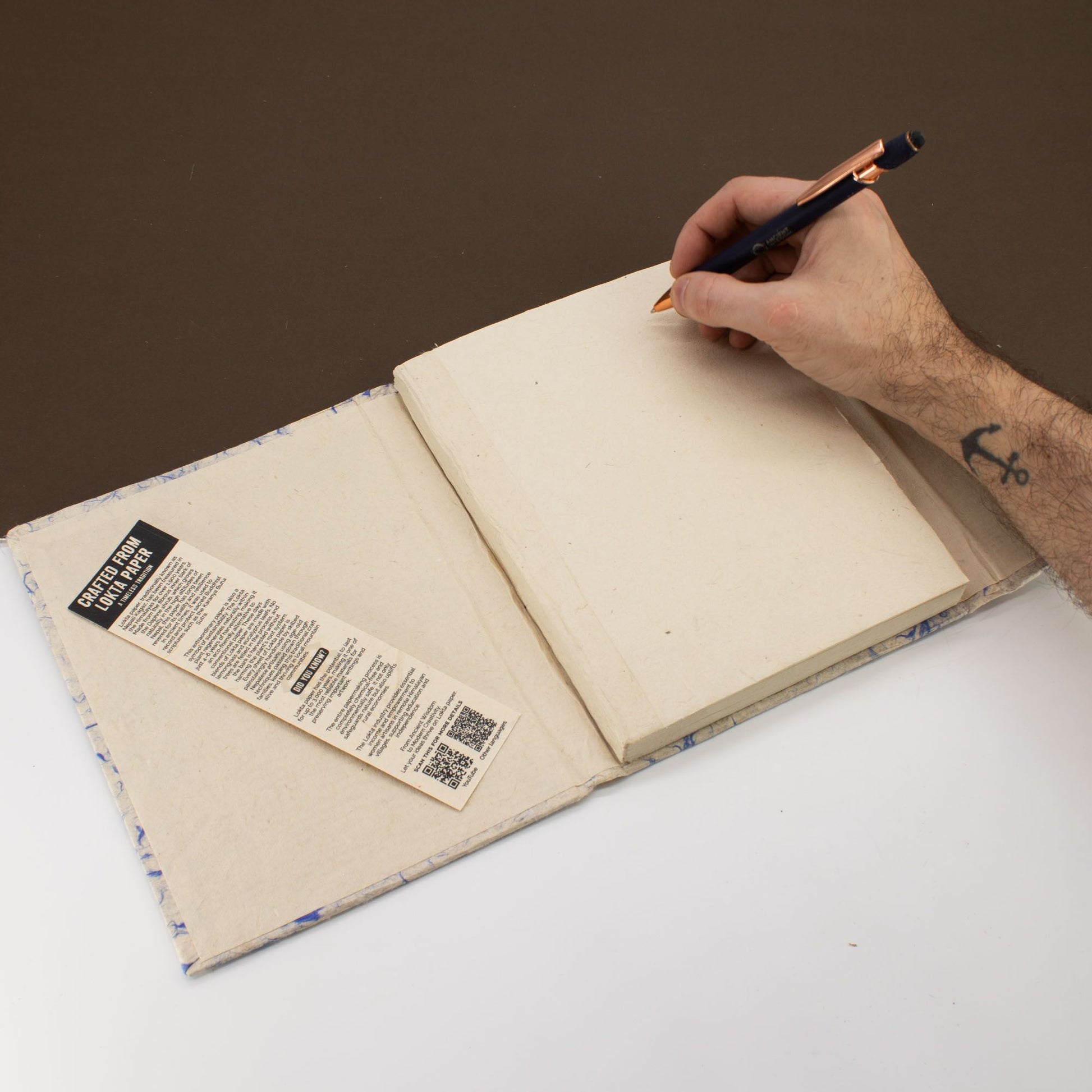 Cuaderno en color beige con papel reciclado, encuadernación artesanal y marcapáginas de cartón.