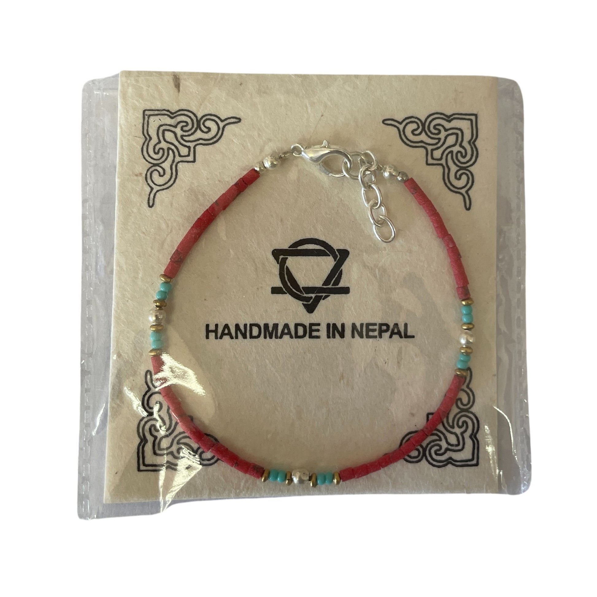 Pulsera hecha a mano en Nepal, con cuentas rojas y azules, estilo bohemio, en empaque ecológico.
