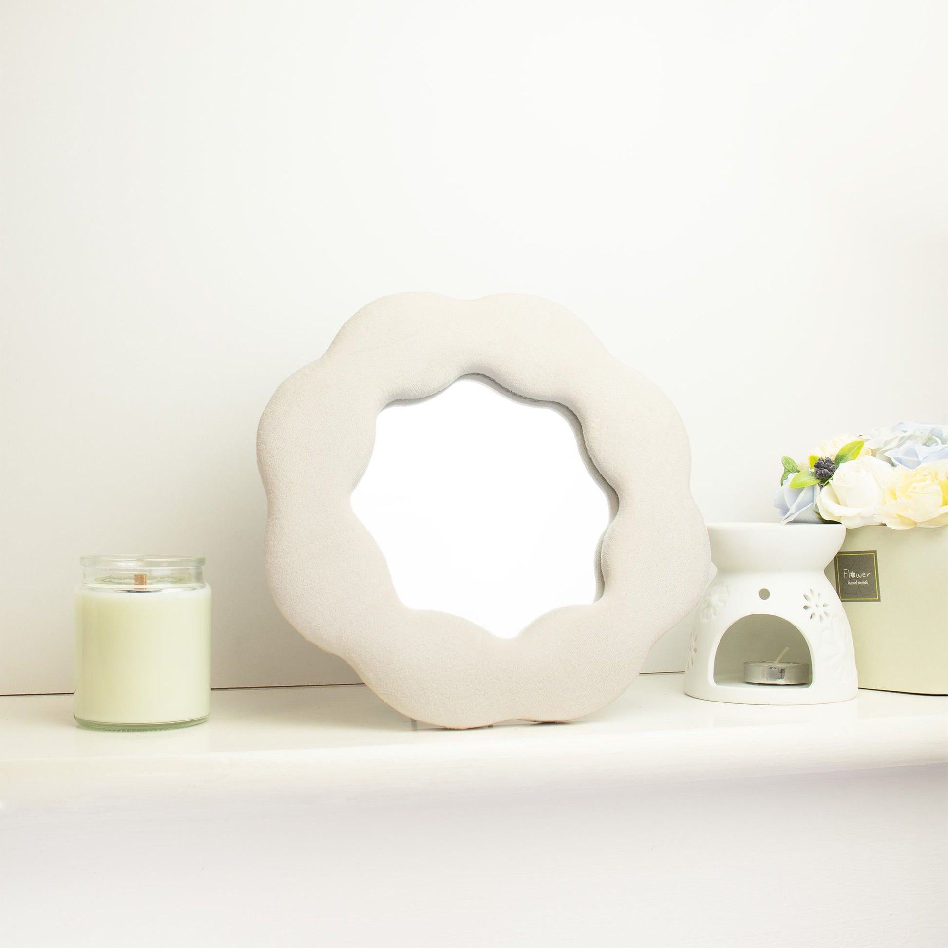 Espejo decorativo en forma de flor, color beige, material suave, ideal para decoración de interiores.