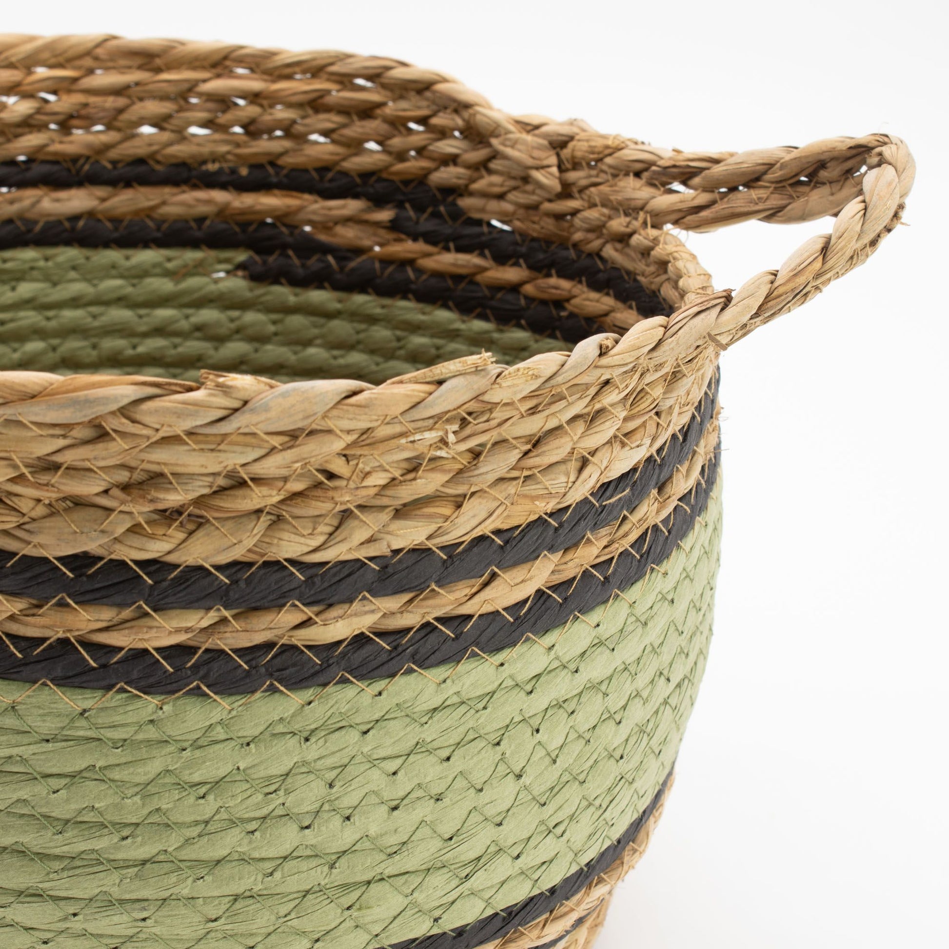 Cesta tejida a mano con pasto marino y algodón en franjas horizontales de color natural, negro y verde.