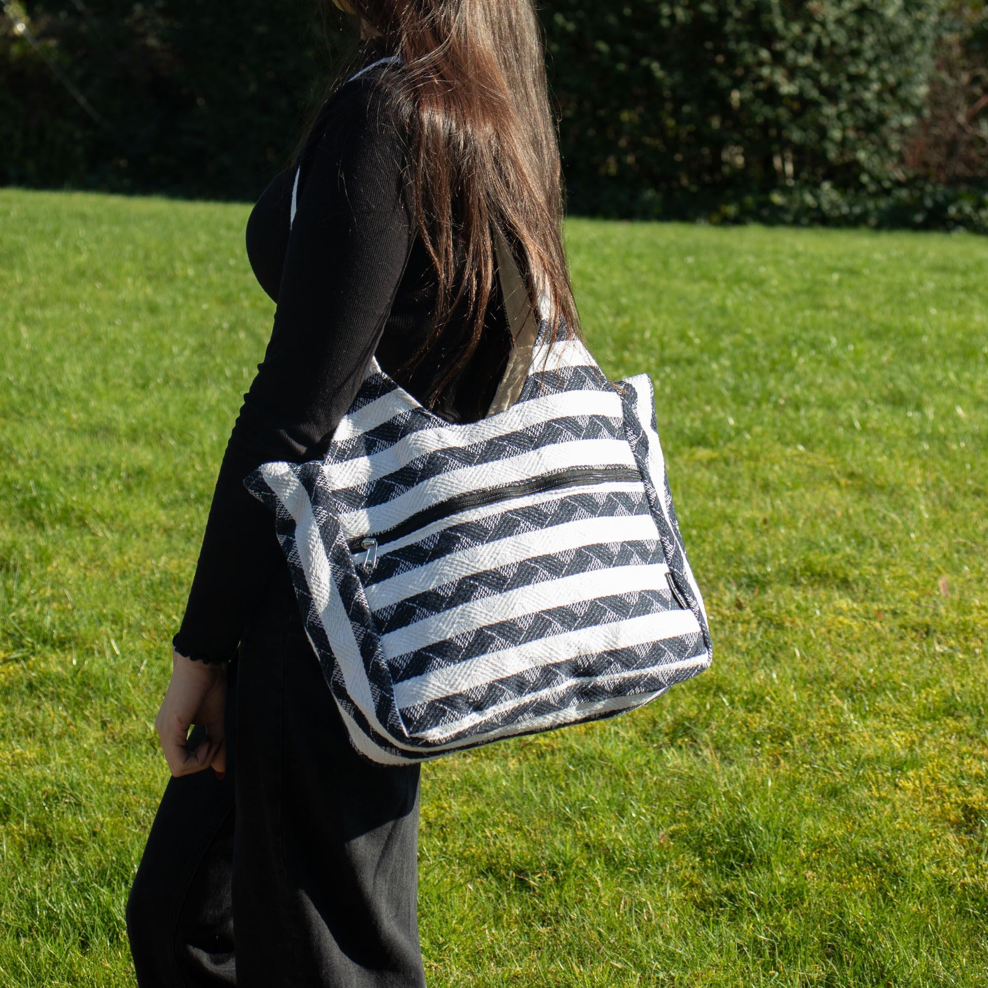 Bolso de mano negro y blanco a rayas, de tela resistente, estilo casual y amplio para uso diario.