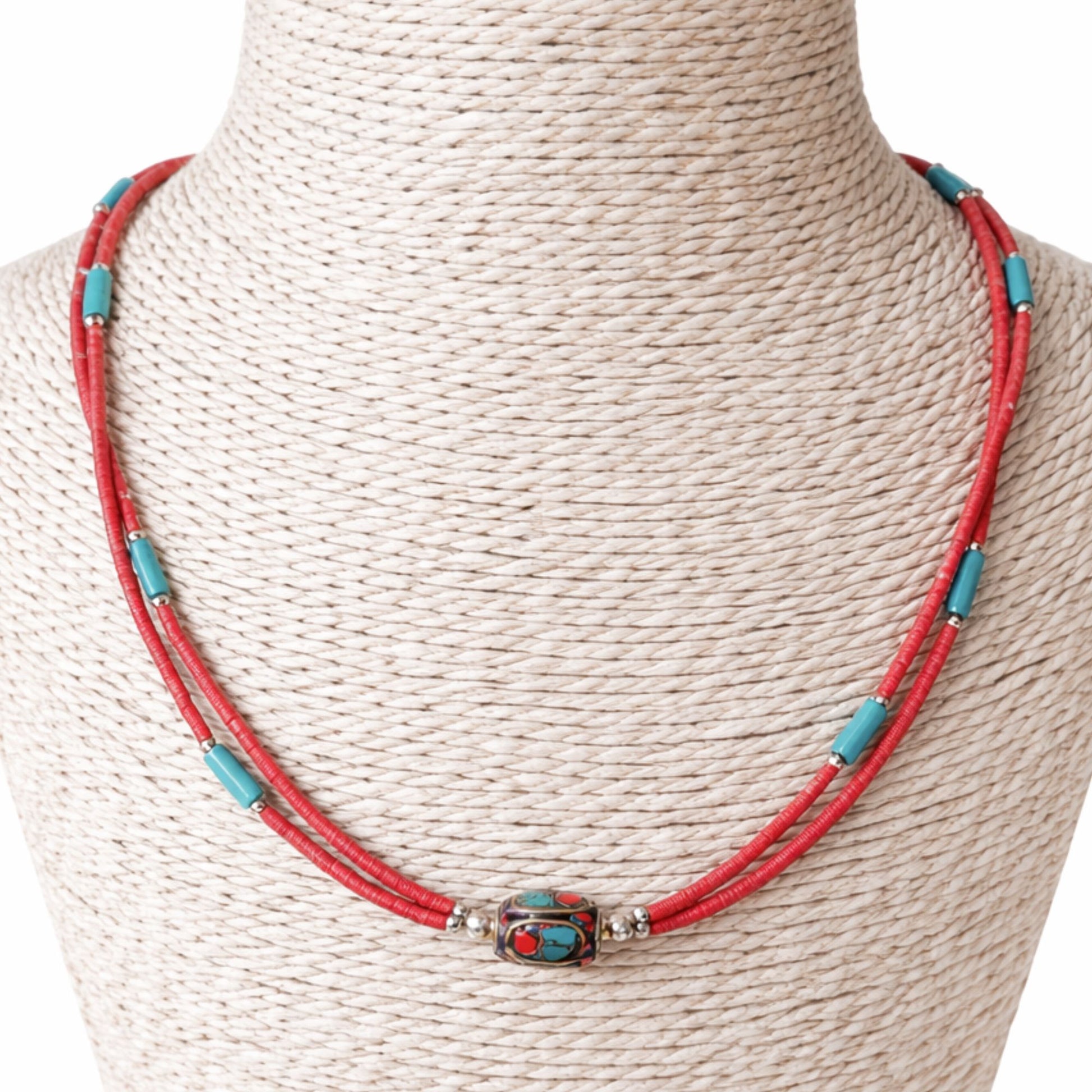 Collar artesanal rojo y turquesa con cuentas de metal, estilo bohemio y materiales naturales.