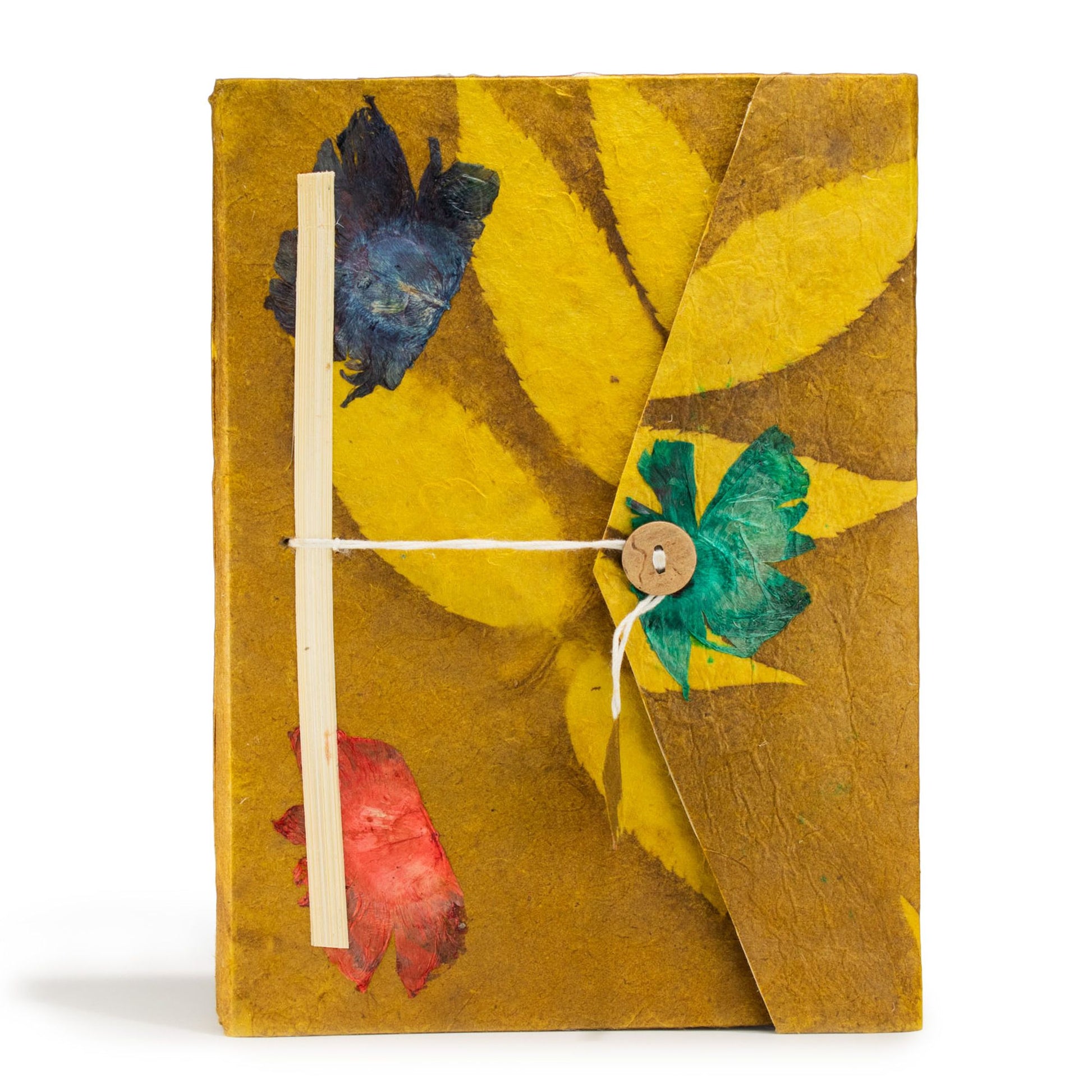 Cuaderno artesanal amarillo con hojas secas en colores azul, verde y rojo, propuesto con encuadernación de cuerda.