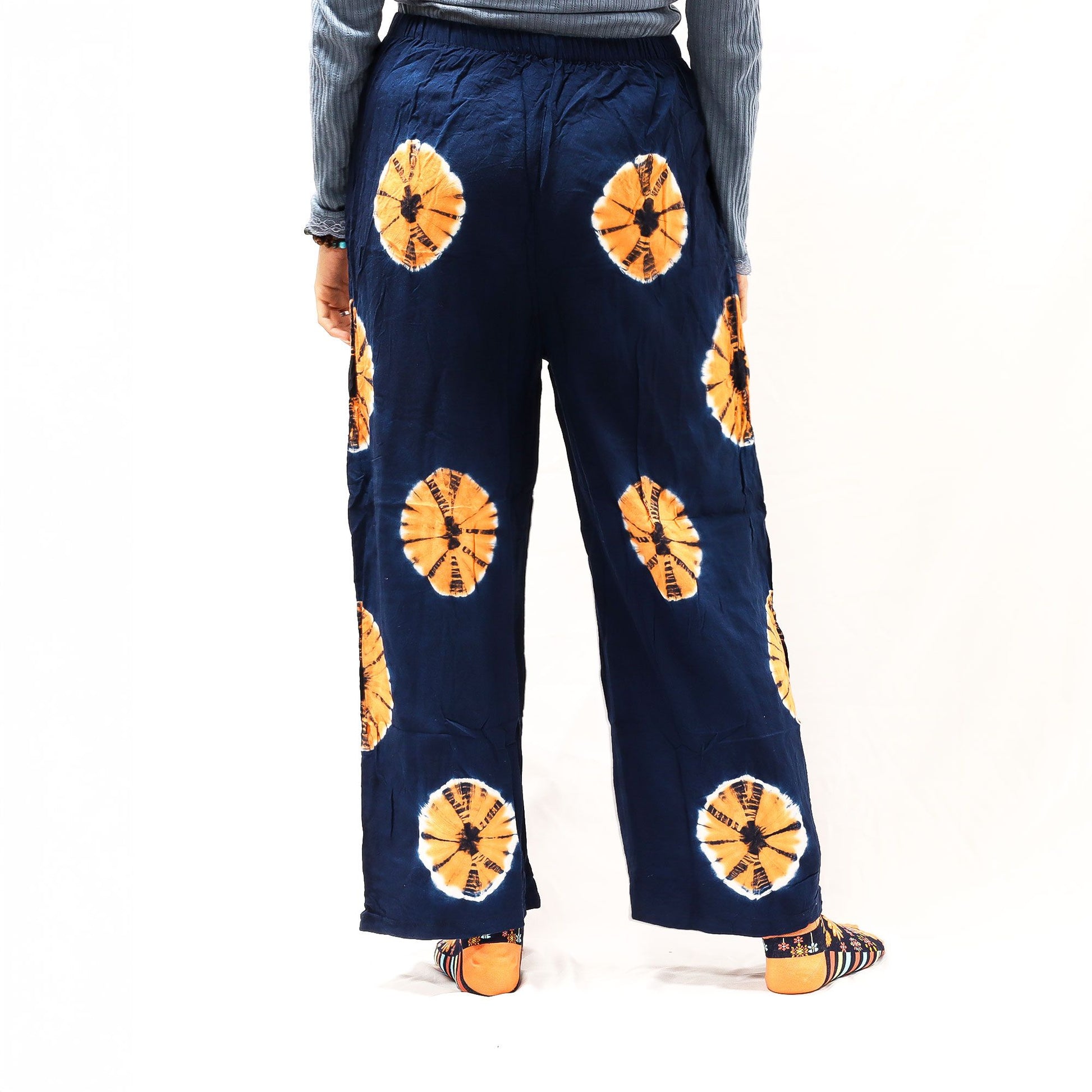 Pantalones de descanso Ancient Wisdom, azul marino con estampado circular naranja, corte holgado y cintura elástica.