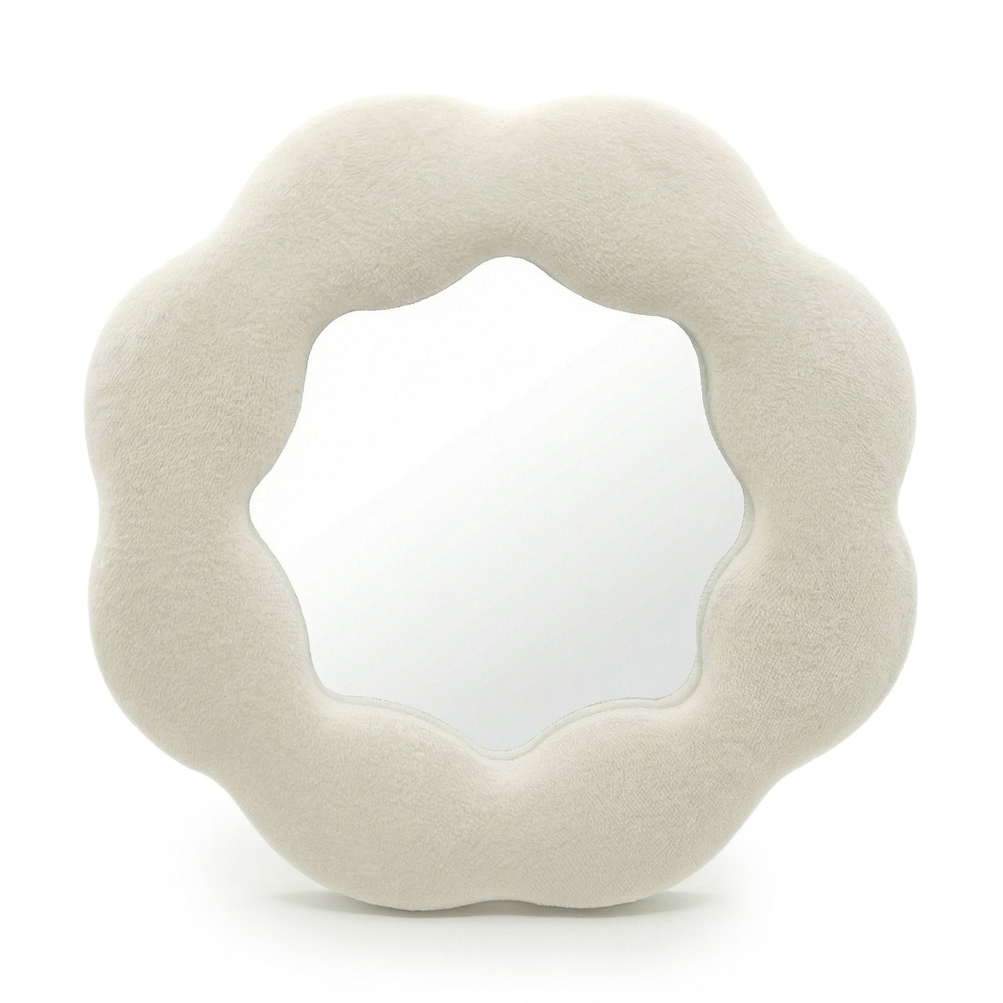 Espejo de pared en forma de flor, tapizado en terciopelo beige suave, con borde ondulado y acabado moderno.