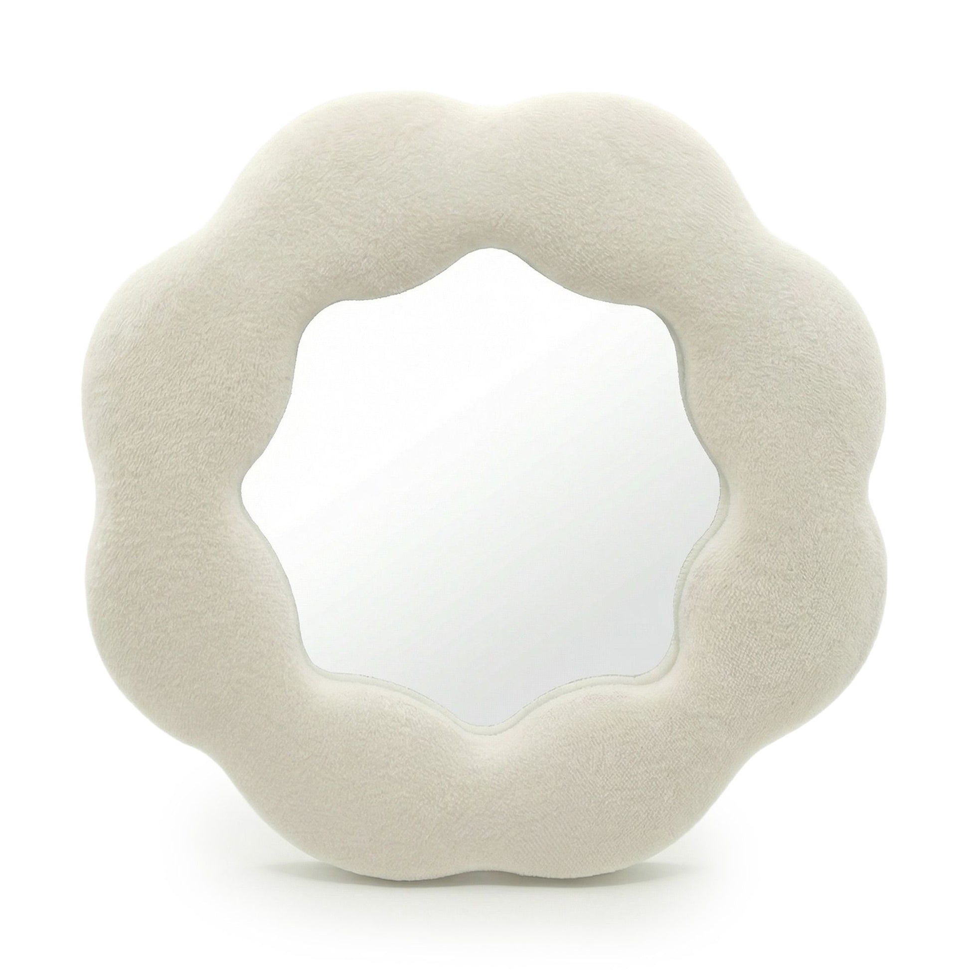 Espejo de pared en forma de flor, tapizado en terciopelo beige suave, con borde ondulado y acabado moderno.