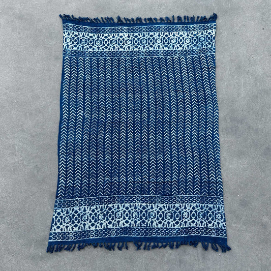 Manta azul marino de algodón con diseño de flechas y borde decorativo, ideal para decoración y abrigo.