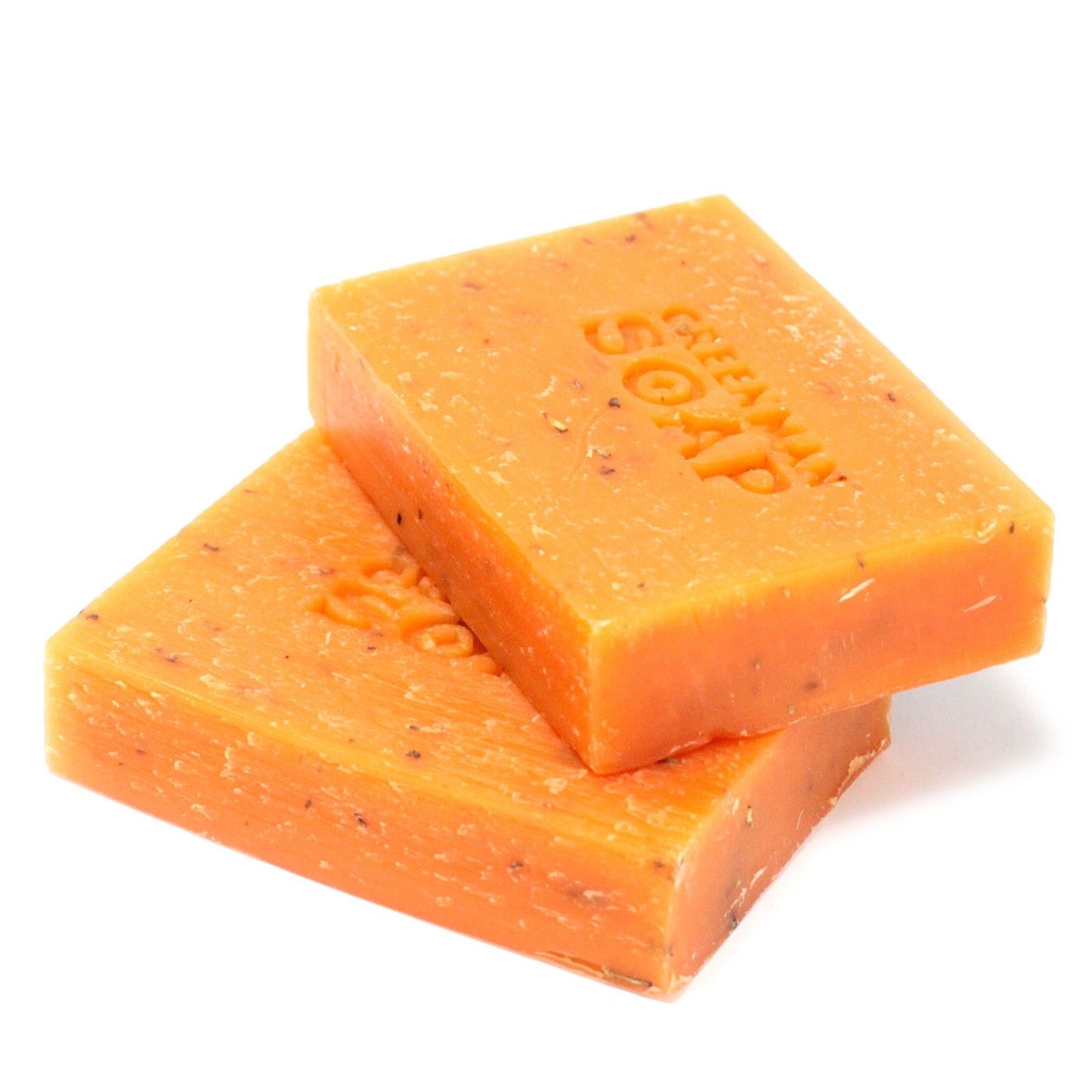 Dos pastillas de jabón naranja, moteadas, apiladas. Tienen grabado el relieve "GREENMAN SOAP" sobre fondo blanco.