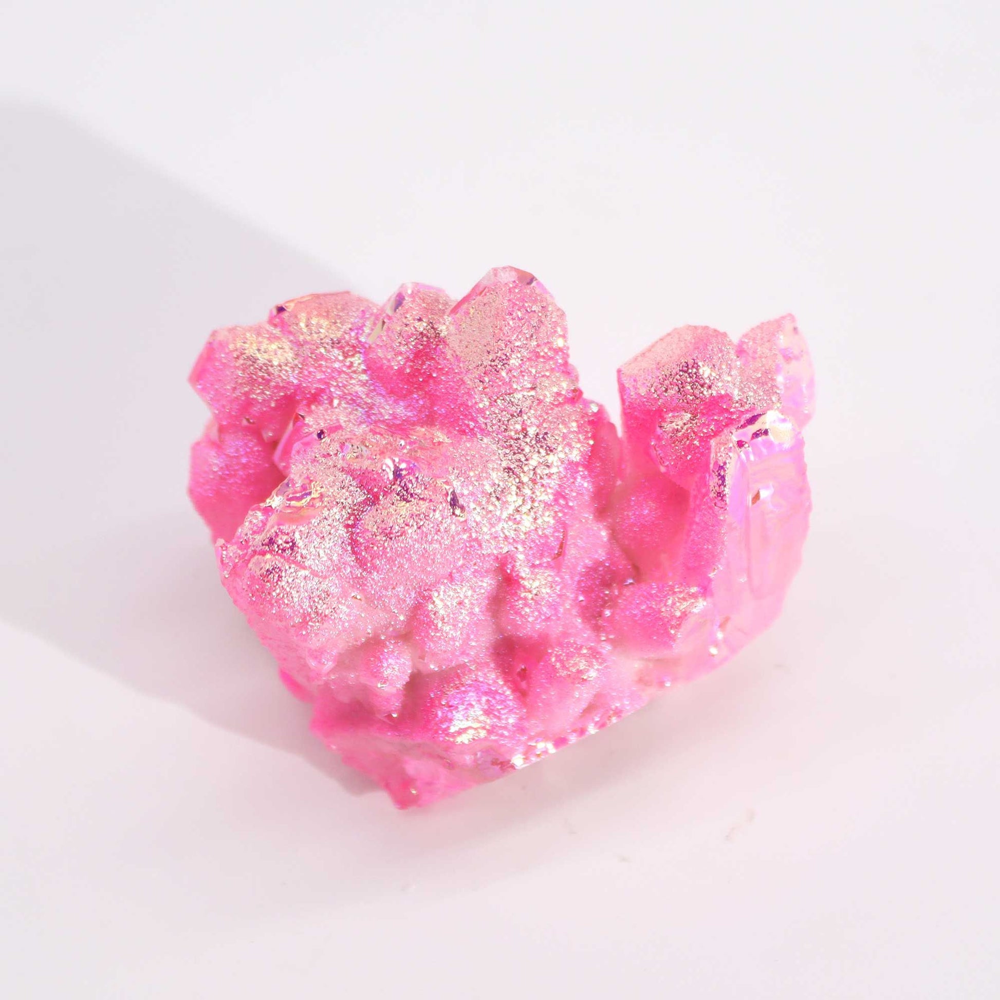 Cristal rosa brillante con destellos dorados, ideal para decoración y coleccionismo.