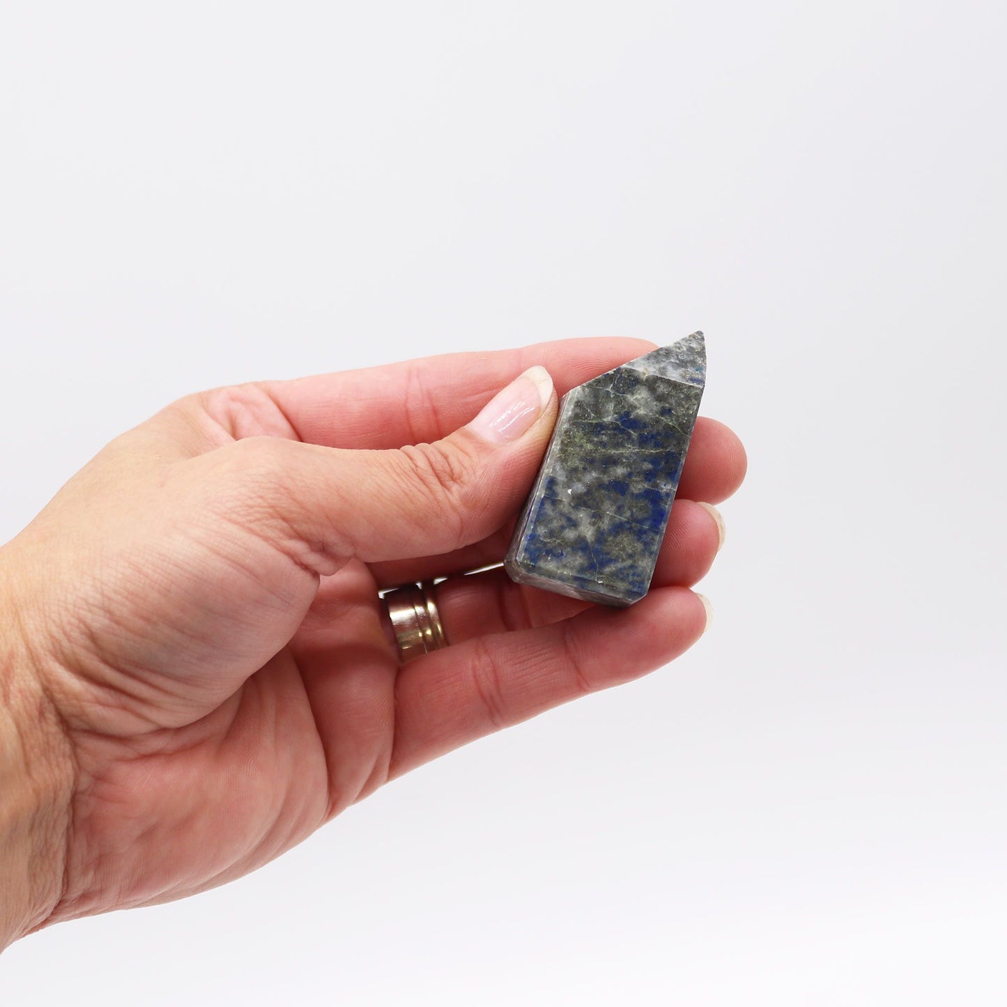 Piedra lapislázuli en forma de punta, colores azul y verde, ideal para joyería y decoración.