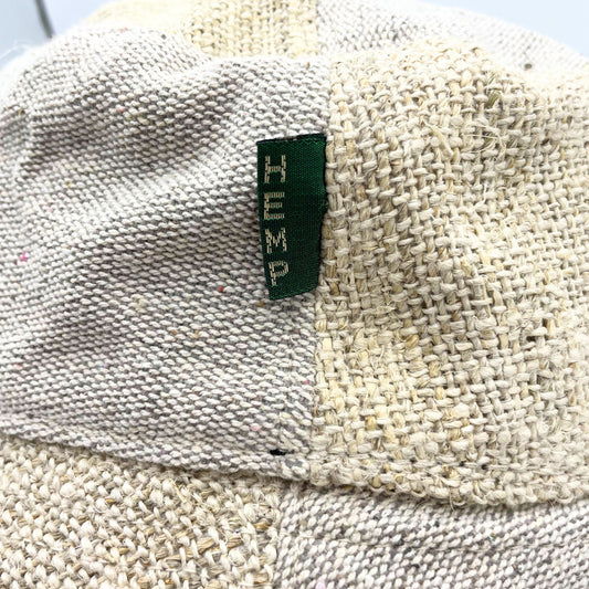 Sombrero de festival estilo boho hecho de parches de cáñamo y algodón en tonos naturales con etiqueta textil verde.