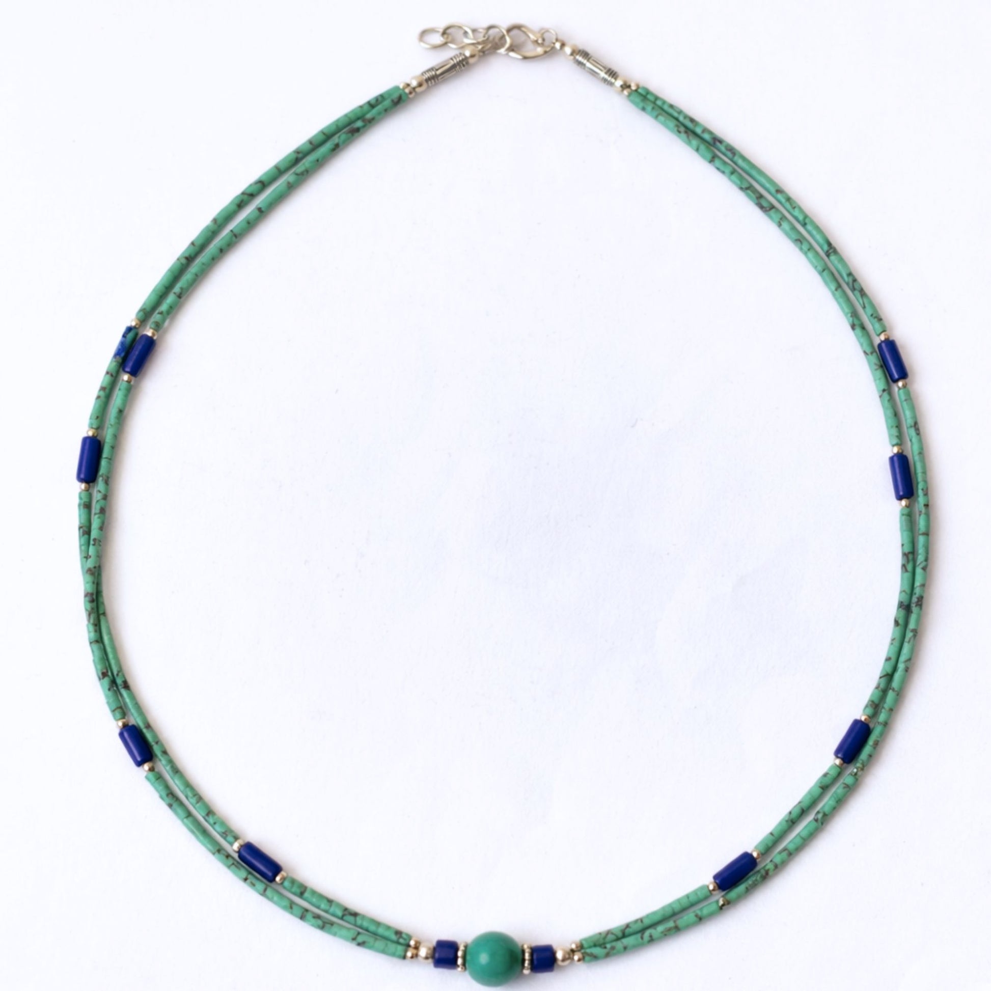 Collar de perlas verdes y azules, hecho de vidrio y metal, con cierre de plata. Estilo moderno y elegante.
