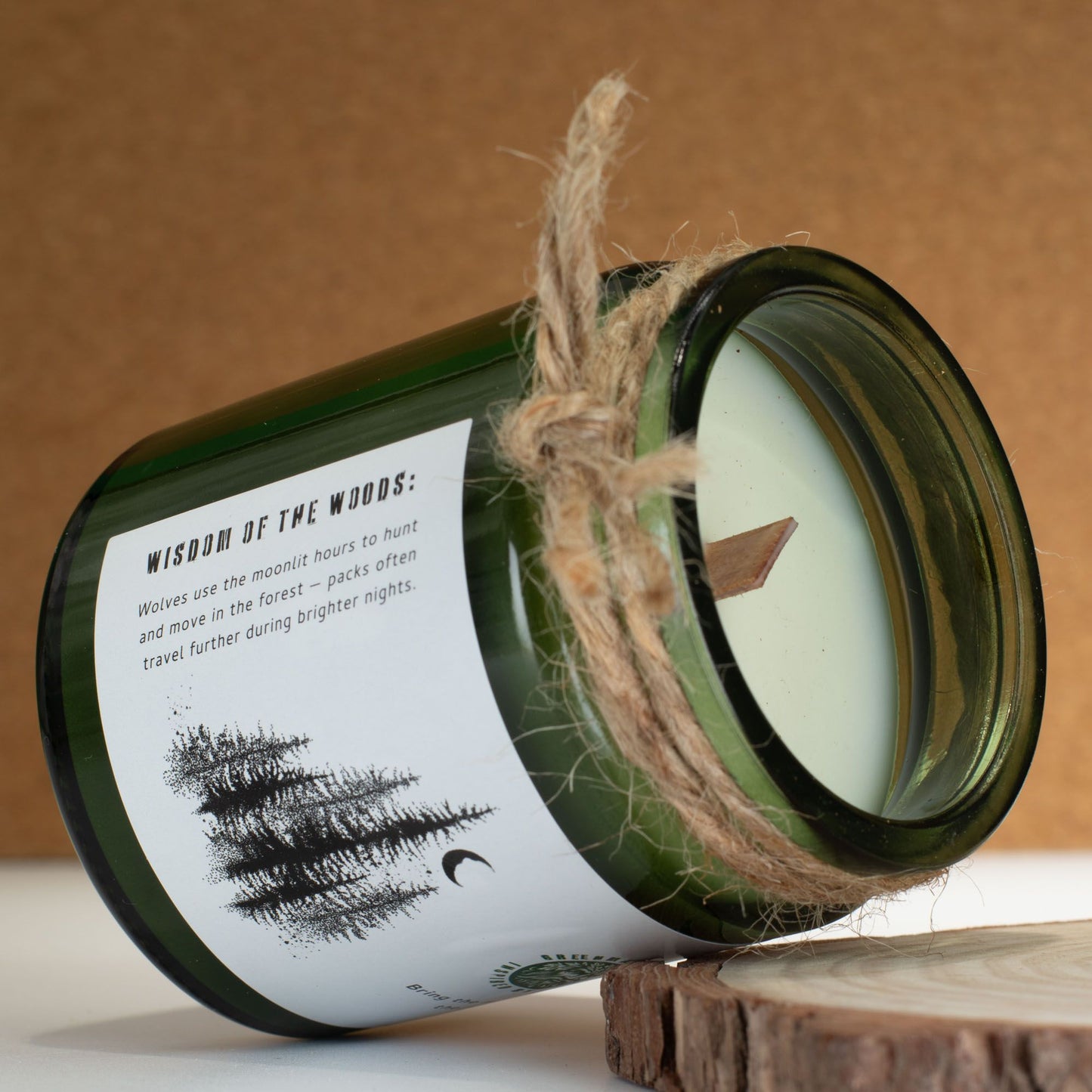 Vela verde en frasco de vidrio con madera y cuerda, aroma "Sabiduría del Bosque". Ideal para decoración rústica.