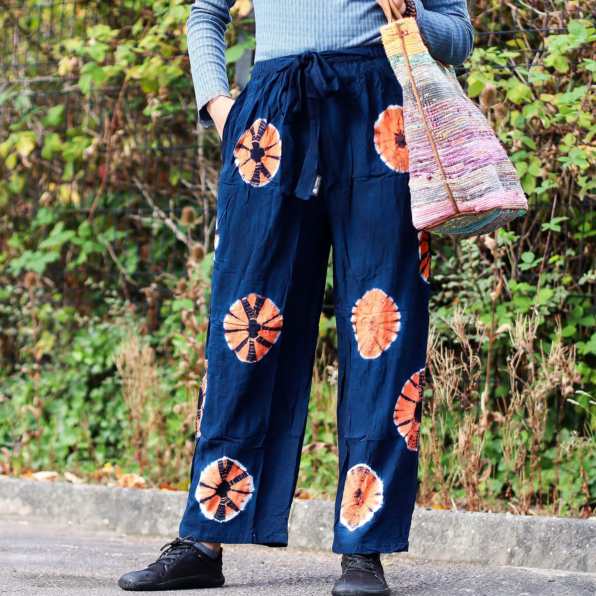 Pantalones de descanso Ancient Wisdom azul marino con estampado circular naranja, corte holgado, cintura con lazo.