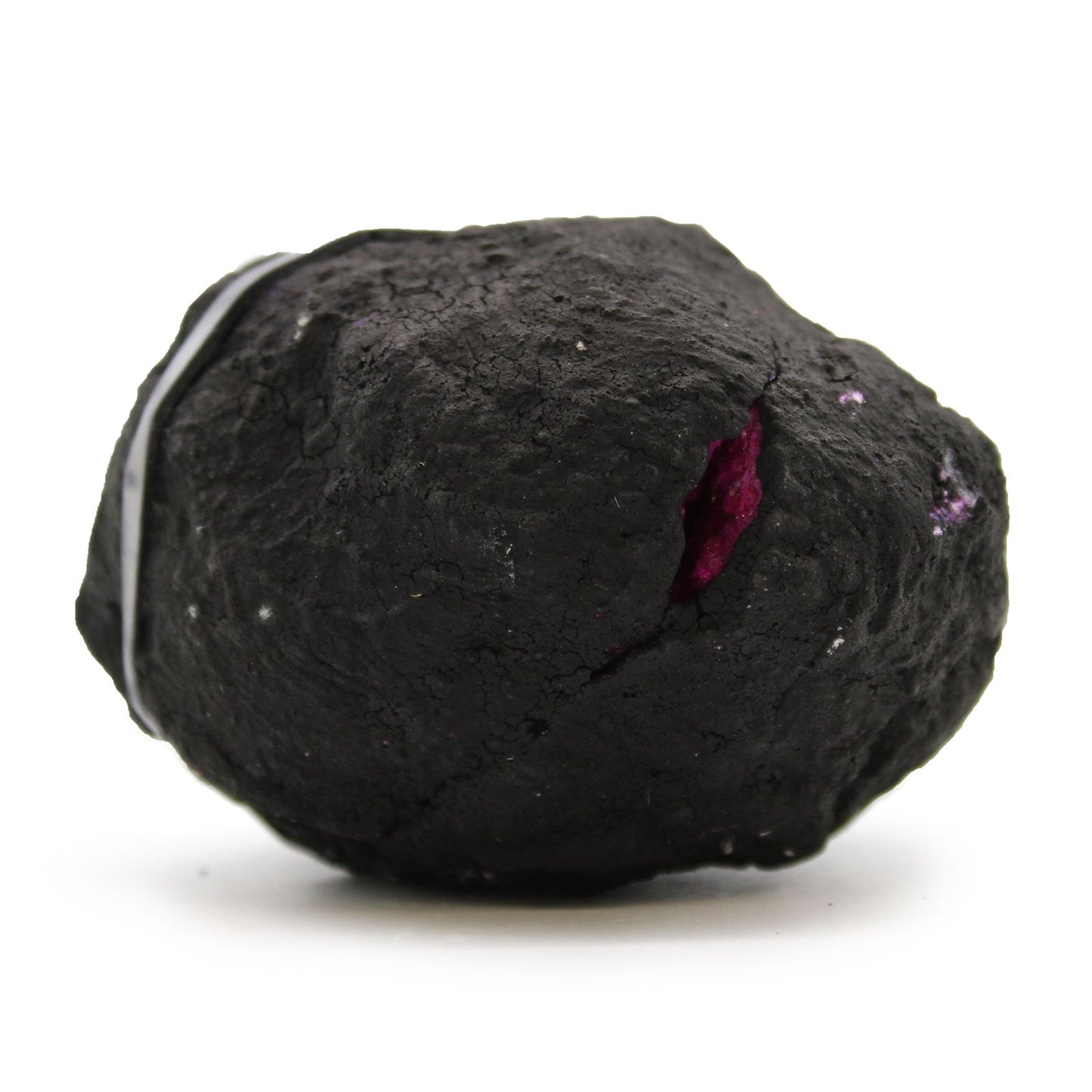 Piedra de mineral negro con inclusiones moradas, textura rugosa y forma irregular, ideal para decoración y joyería.