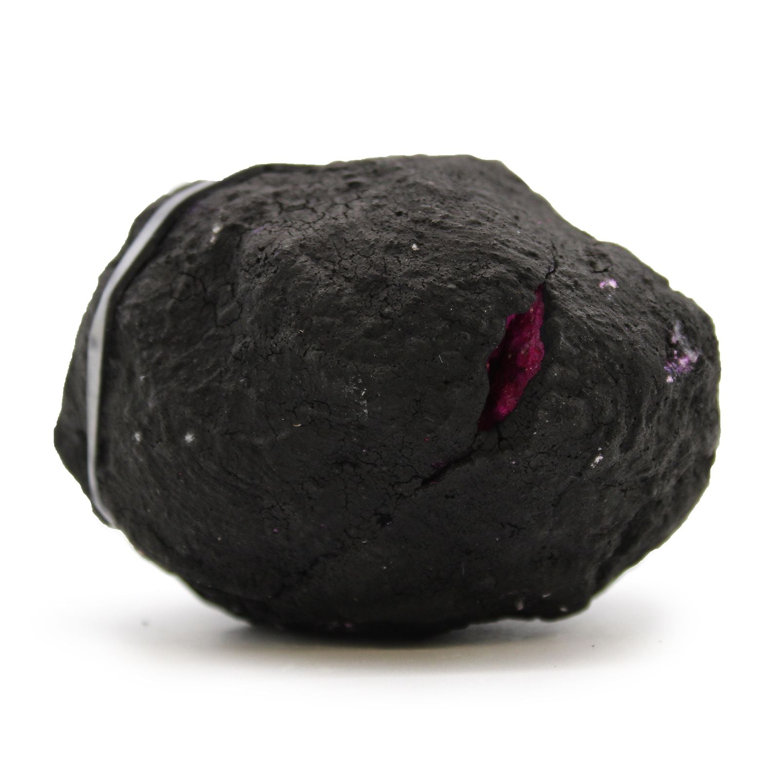 Piedra de mineral negro con inclusiones moradas, textura rugosa y forma irregular, ideal para decoración y joyería.