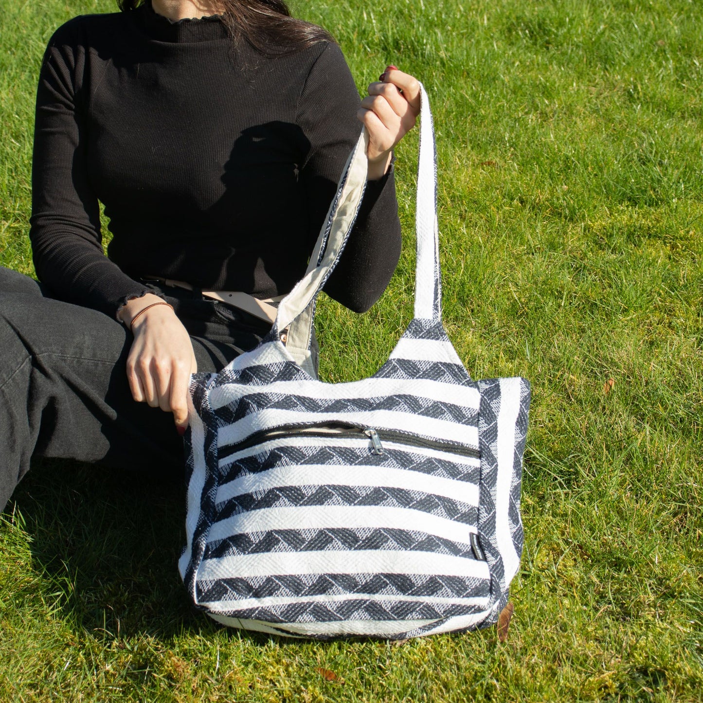 Bolso de tela negro y blanco con rayas, estilo casual, ideal para uso diario.