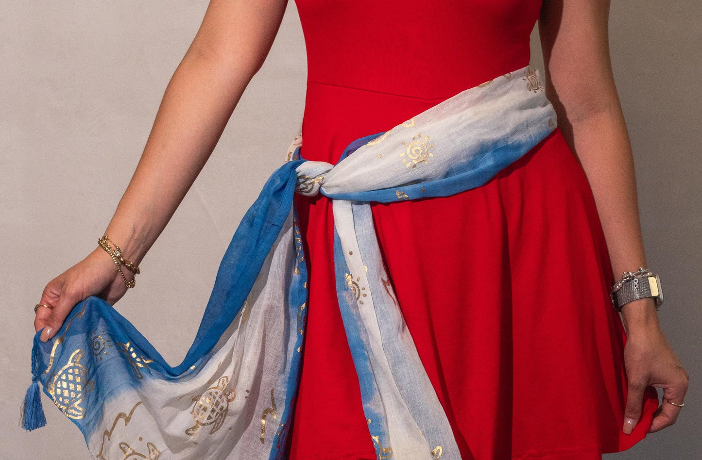 Fular de seda azul y blanco con detalles dorados, ideal para complementar un vestido rojo.