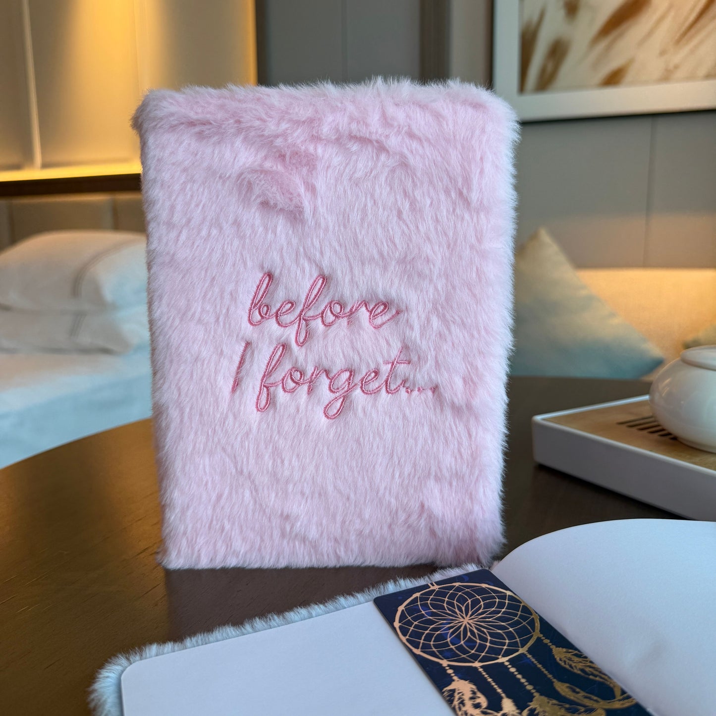 Cuaderno de peluche rosa con bordado "before I forget..." en estilo moderno y suave.