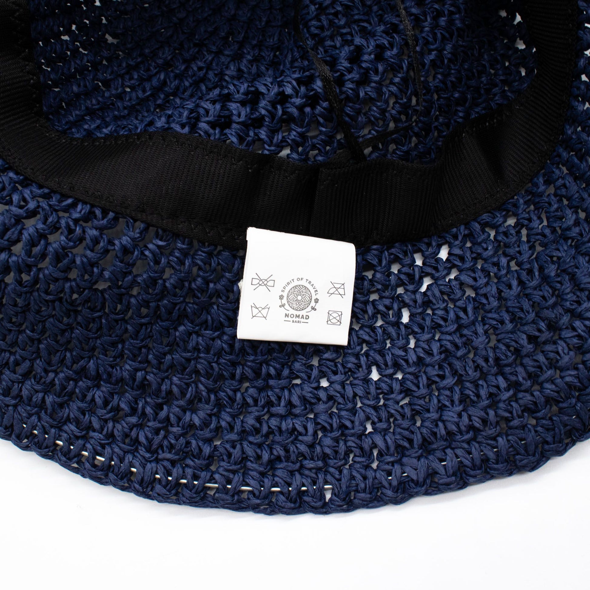 Sombrero de paja azul marino con etiqueta, estilo casual y detalle de cinta negra en el interior.