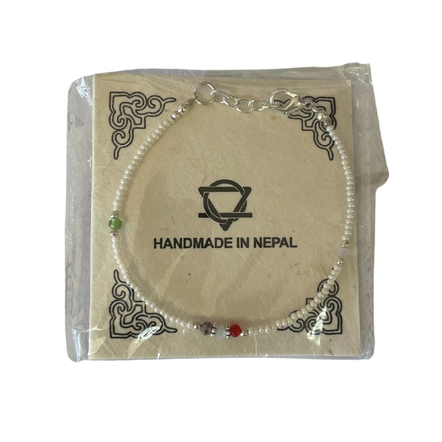 Brazalete hecho a mano en Nepal, perlas blancas con detalles en verde, rojo y morado, elegante y único.