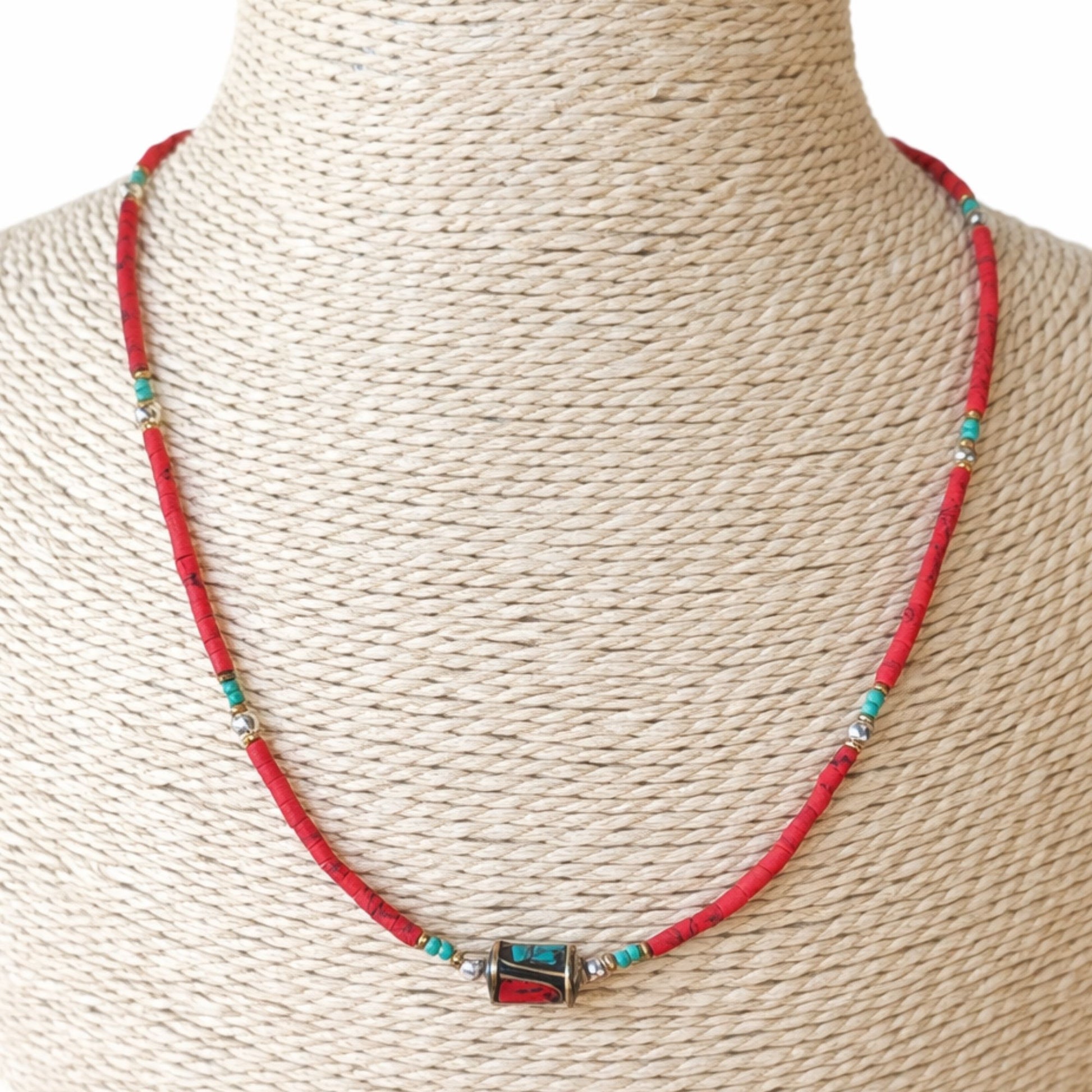 Collar artesanal rojo y turquesa de cuentas, con detalle metálico, estilo bohemio elegante.