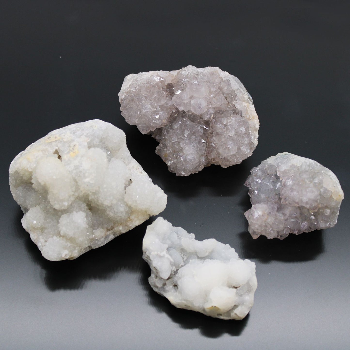 Piedras de cristal gris y púrpura, variedades de cuarzo, decorativas y brillantes, fondo negro.