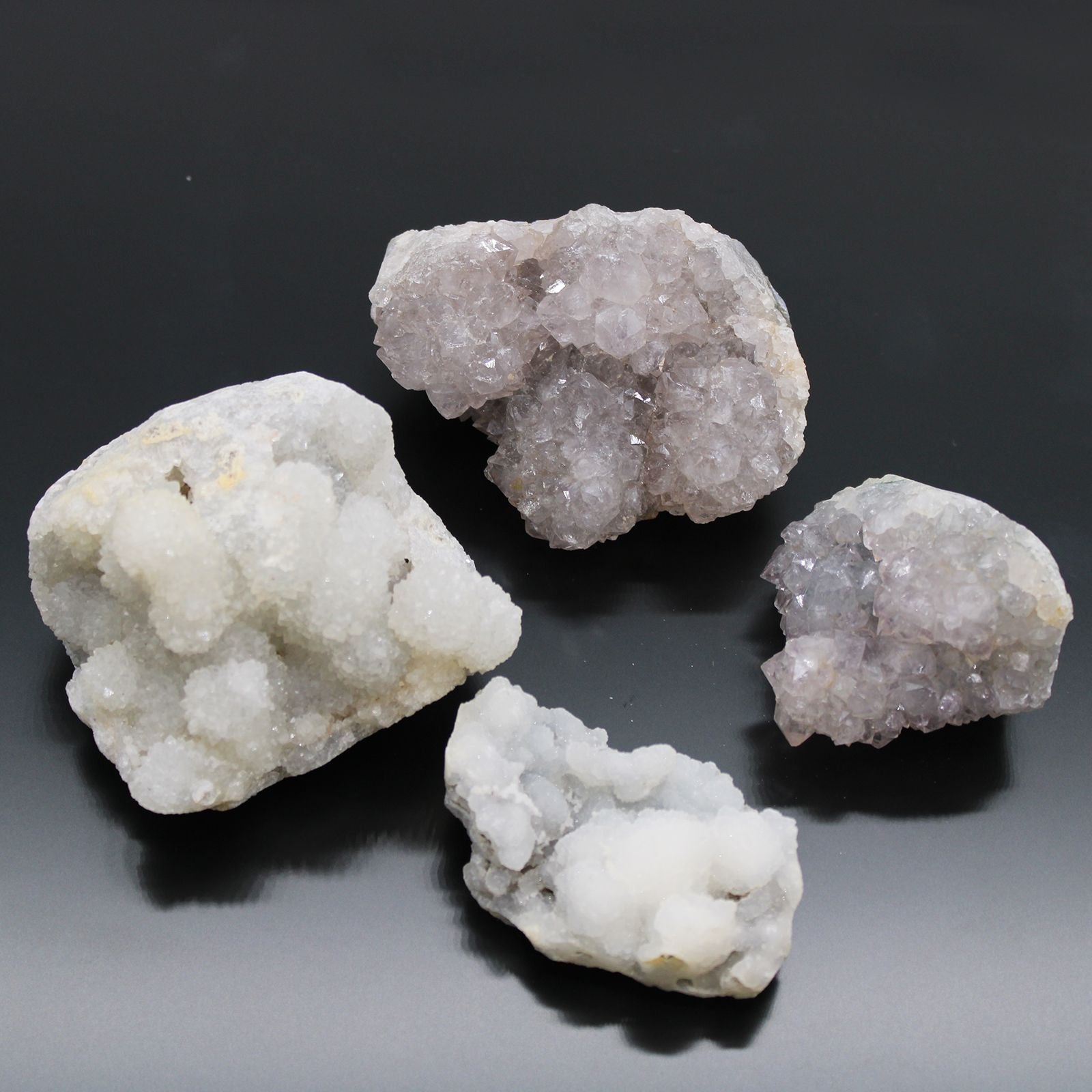 Piedras de cristal gris y púrpura, variedades de cuarzo, decorativas y brillantes, fondo negro.