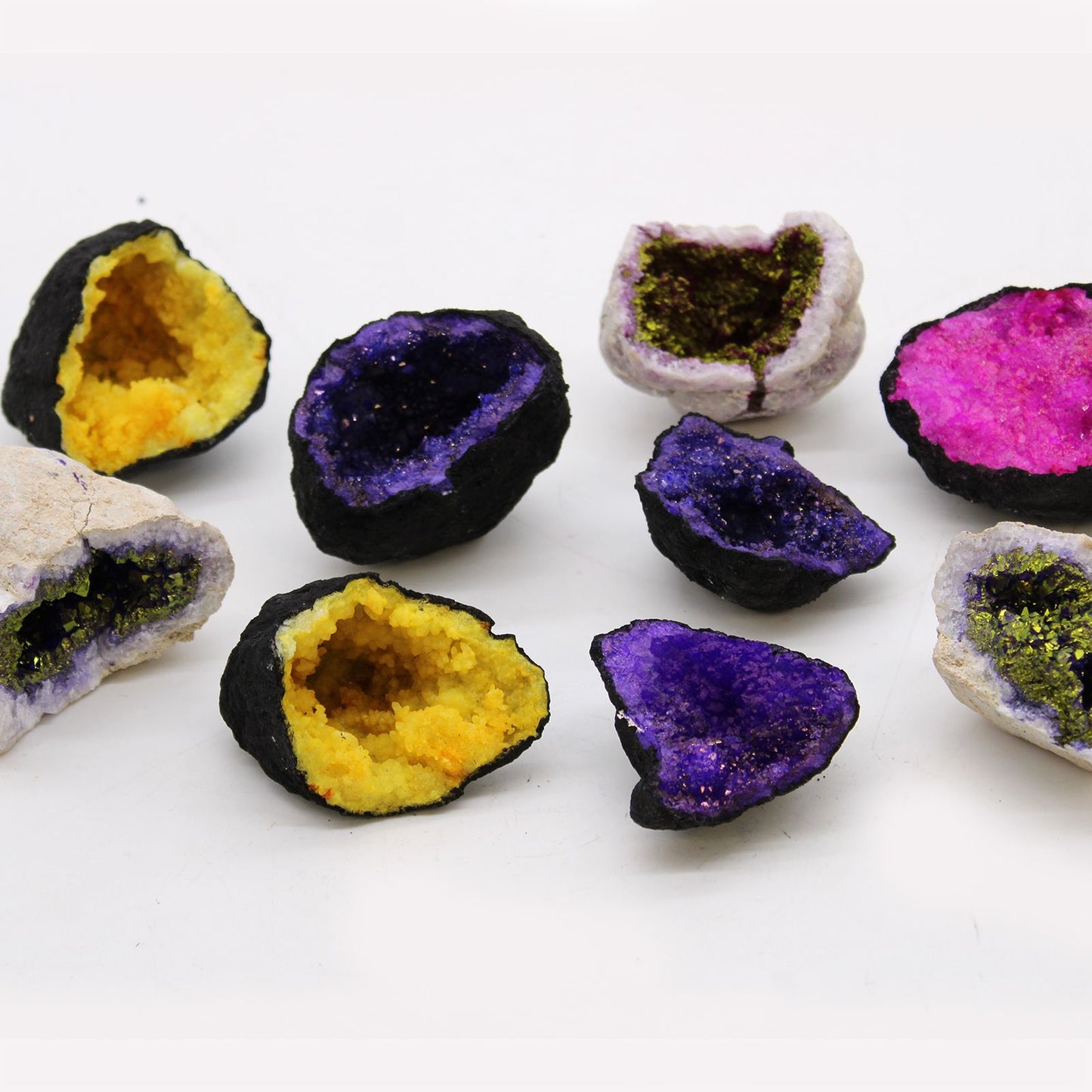 Minerales geodes en tonos morado, amarillo y rosa, con superficie negra. Decoración natural única y colorida.