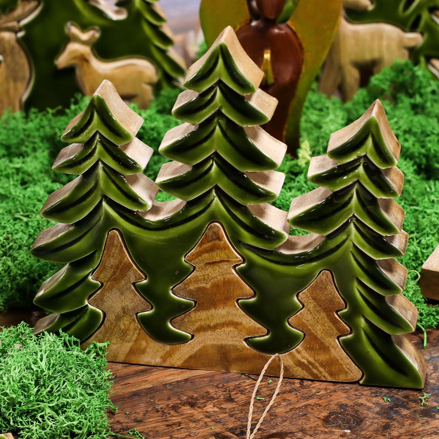 Figuras de madera en tonalidades verdes, estilo rústico, representando árboles en miniatura para decoración.