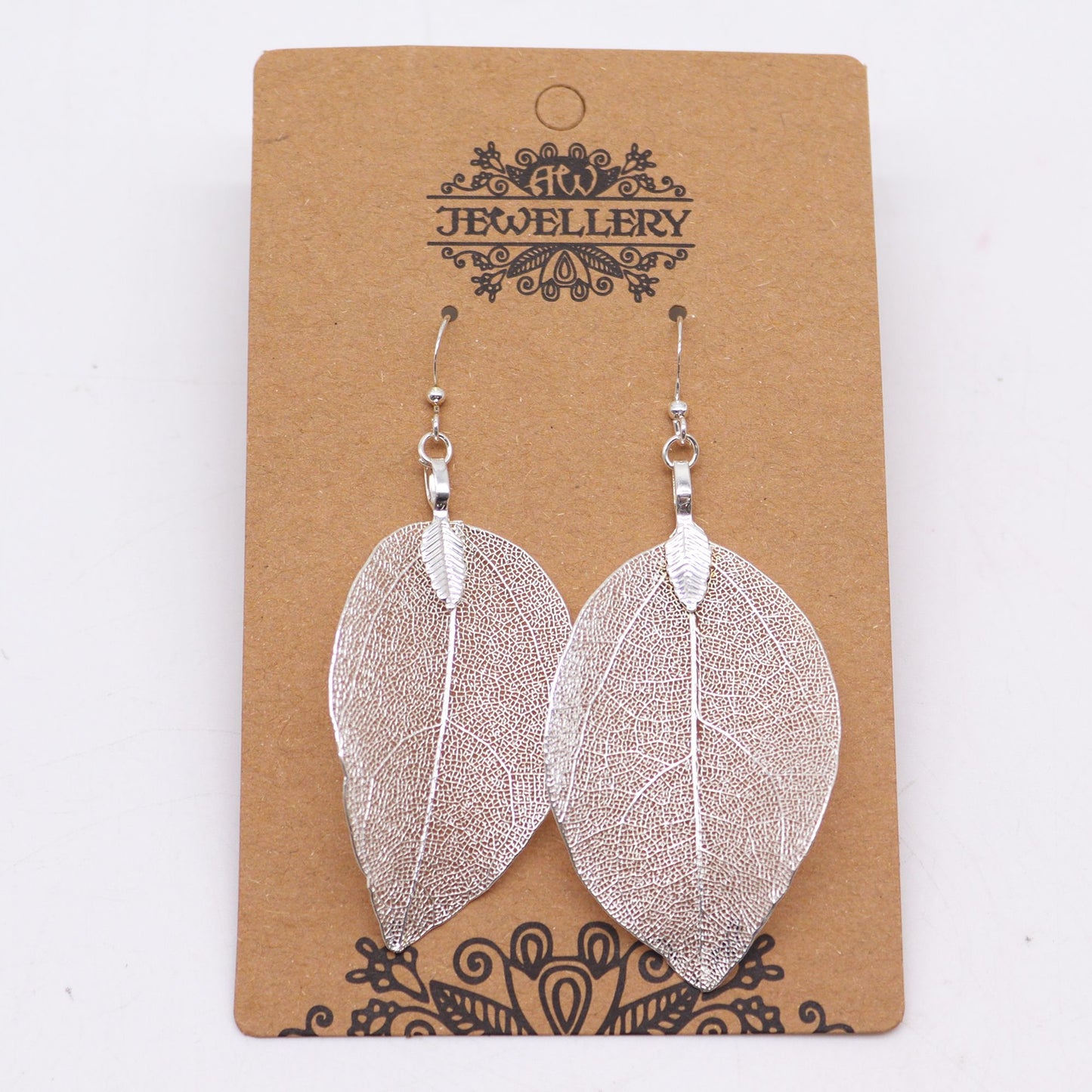 Pendientes de plata en forma de hojas, con diseño detallado y estilo elegante, presentados en tarjeta kraft.