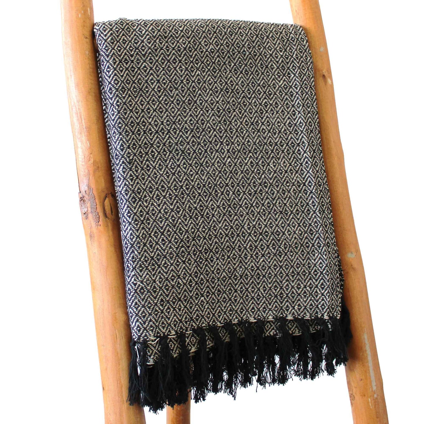 Manta de algodón negro y beige con diseño geométrico y flecos, perfecta para decoración moderna.
