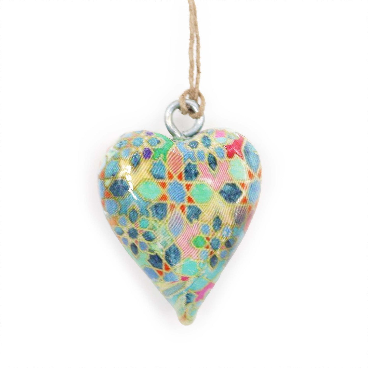 Corazón de cerámica colorido con diseño geométrico, colgado con cuerda, estilo artesanal.