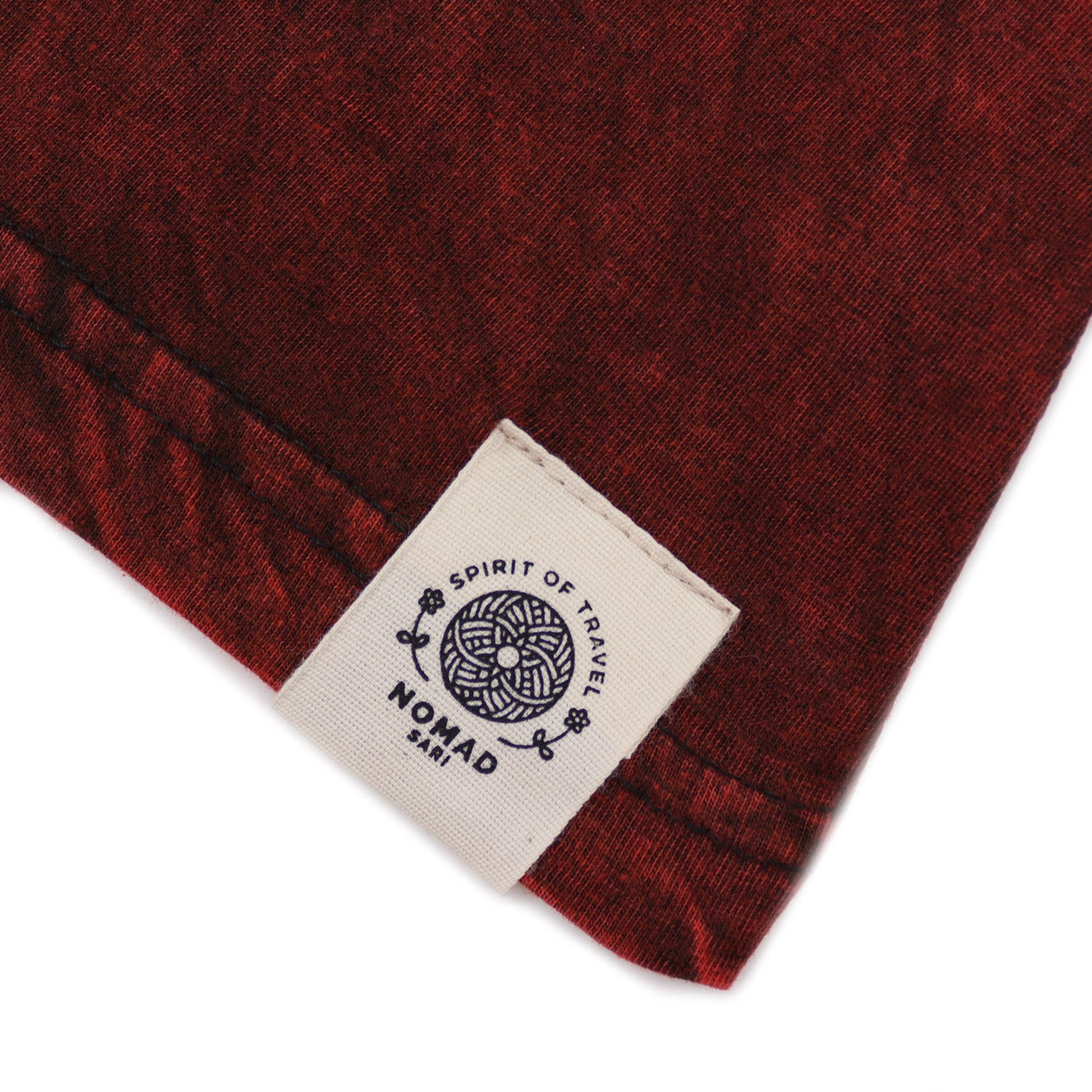 Camisa de algodón roja oscuro con etiqueta de marca Nomad, estilo casual y diseño moderno.