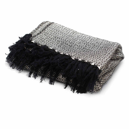 Manta de algodón gris con patrón geométrico y flecos negros, estilo moderno y acogedor.