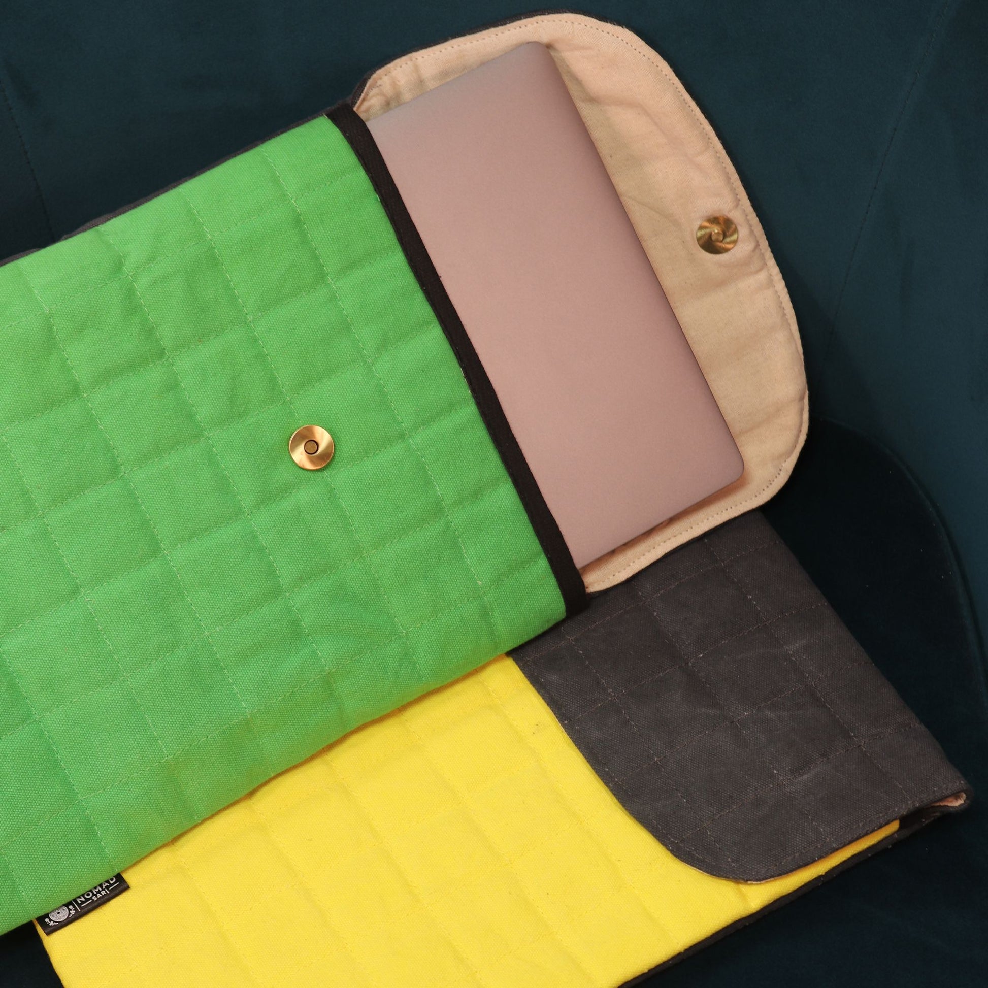 Funda acolchada para laptop en verde, amarillo y gris, con cierre de botón y material resistente.