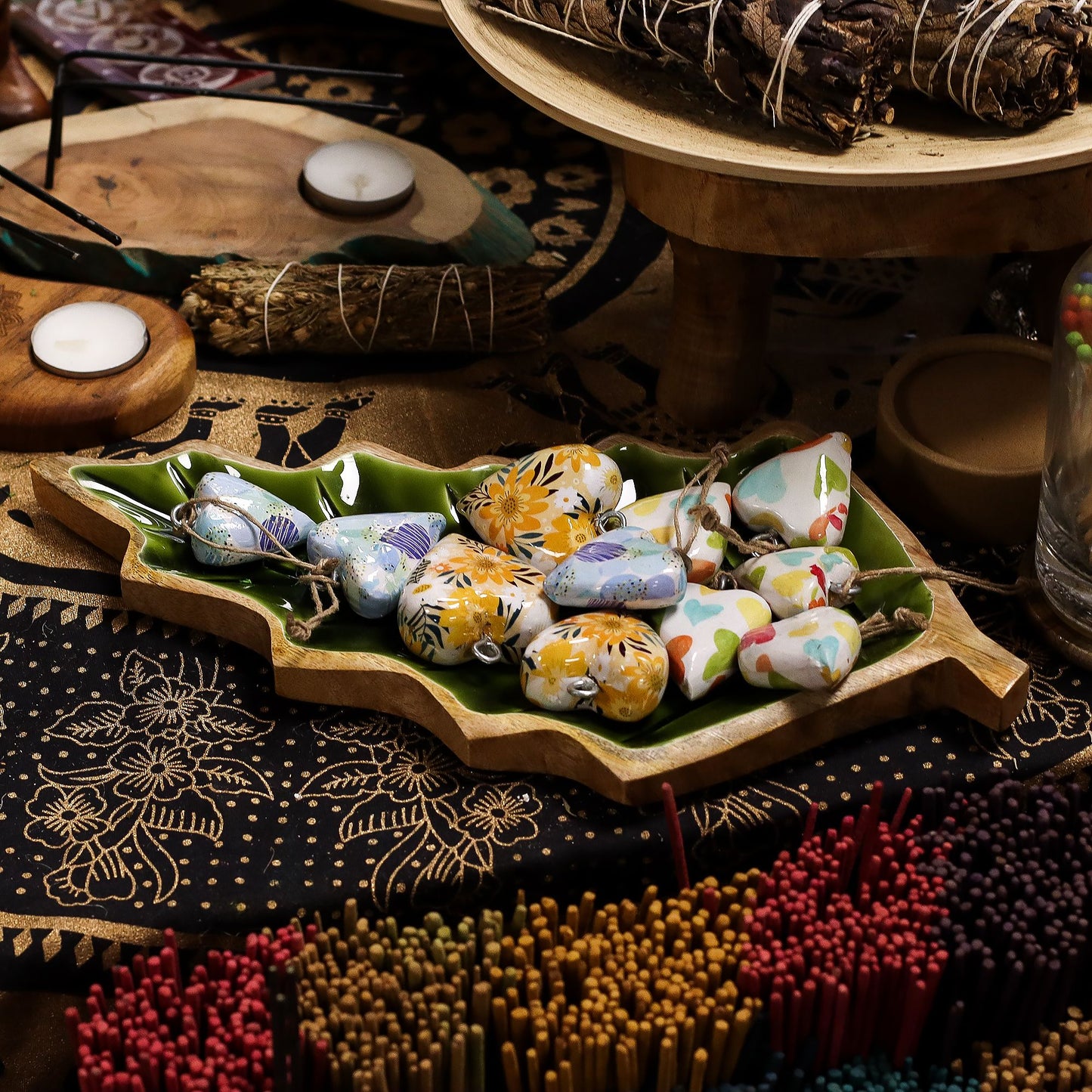 Jarrones decorativos de cerámica colorida en bandeja verde, ideales para adornar espacios bohemios.