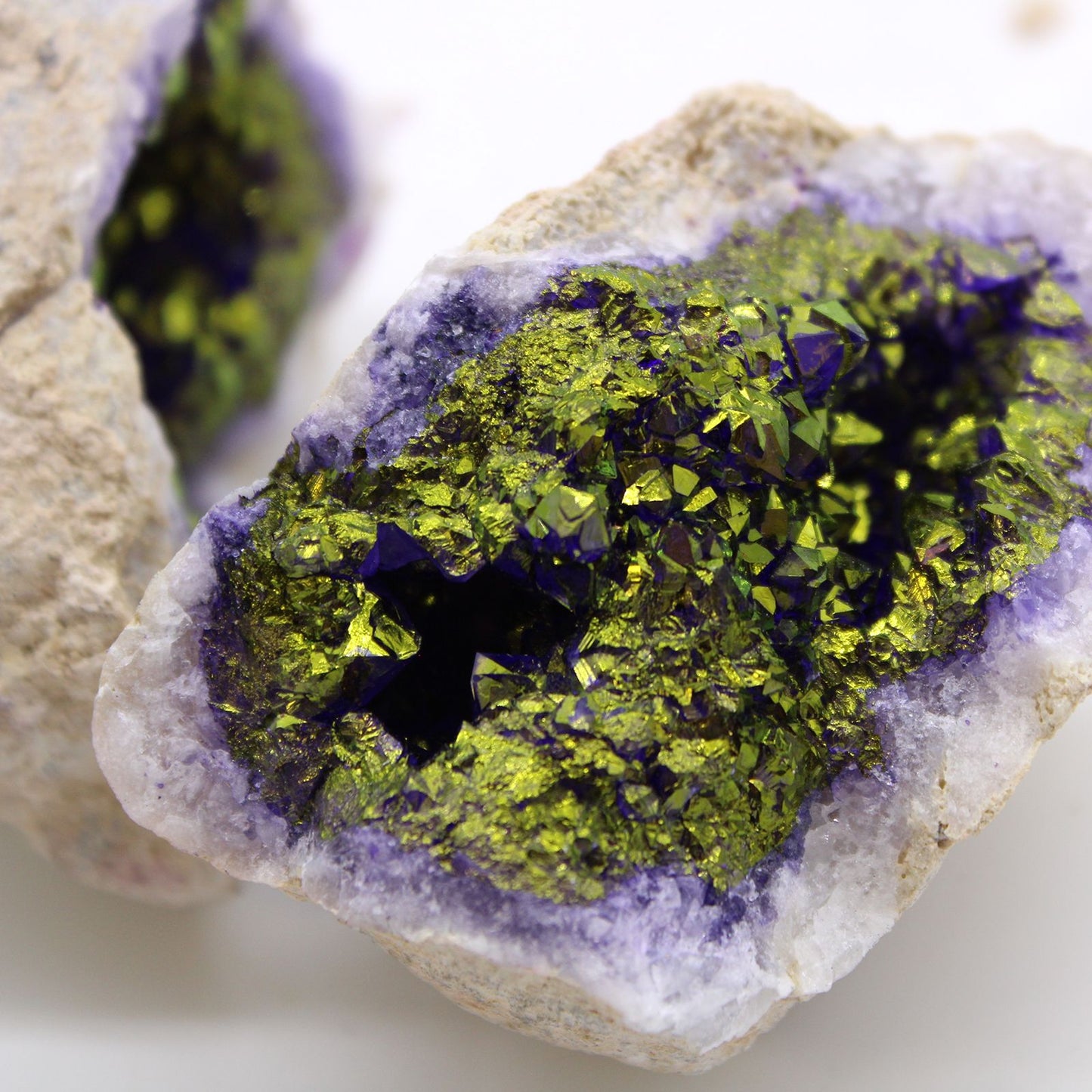 Cristal de amatista verde y morado, con brillos metálicos, ideal para decoración y joyería.