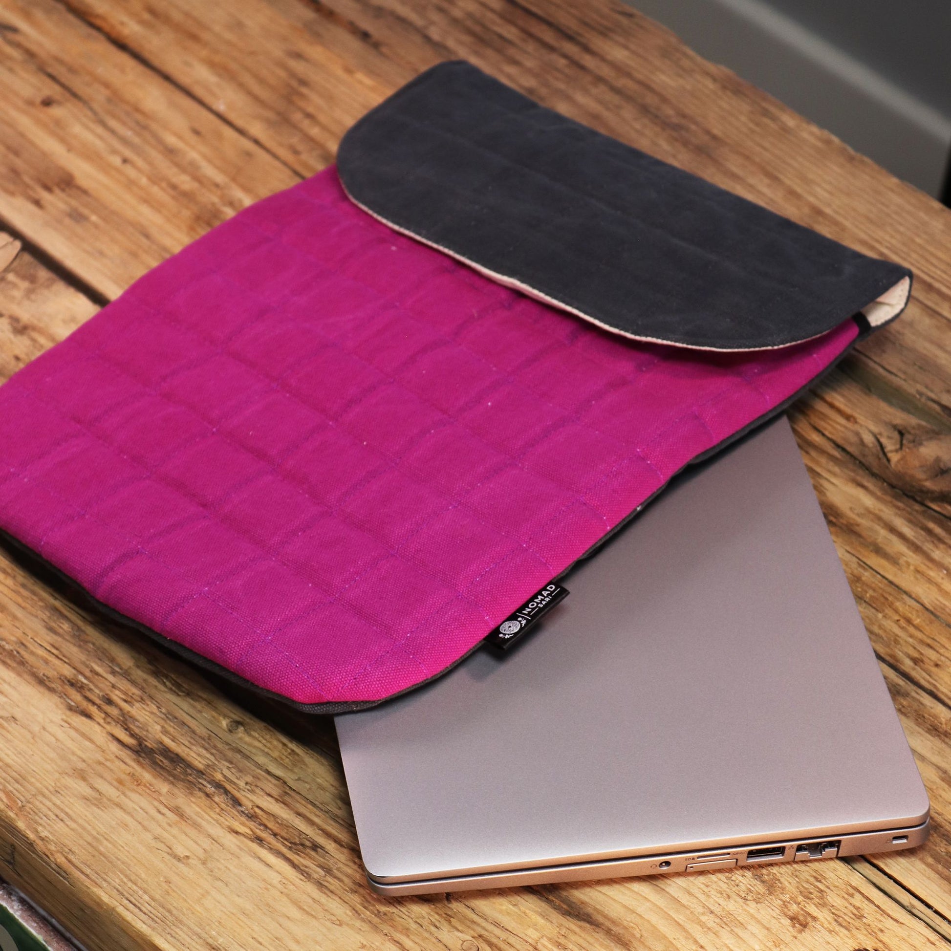 Funda para laptop de algodón rosa y gris con textura acolchada, ideal para proteger dispositivos electrónicos.