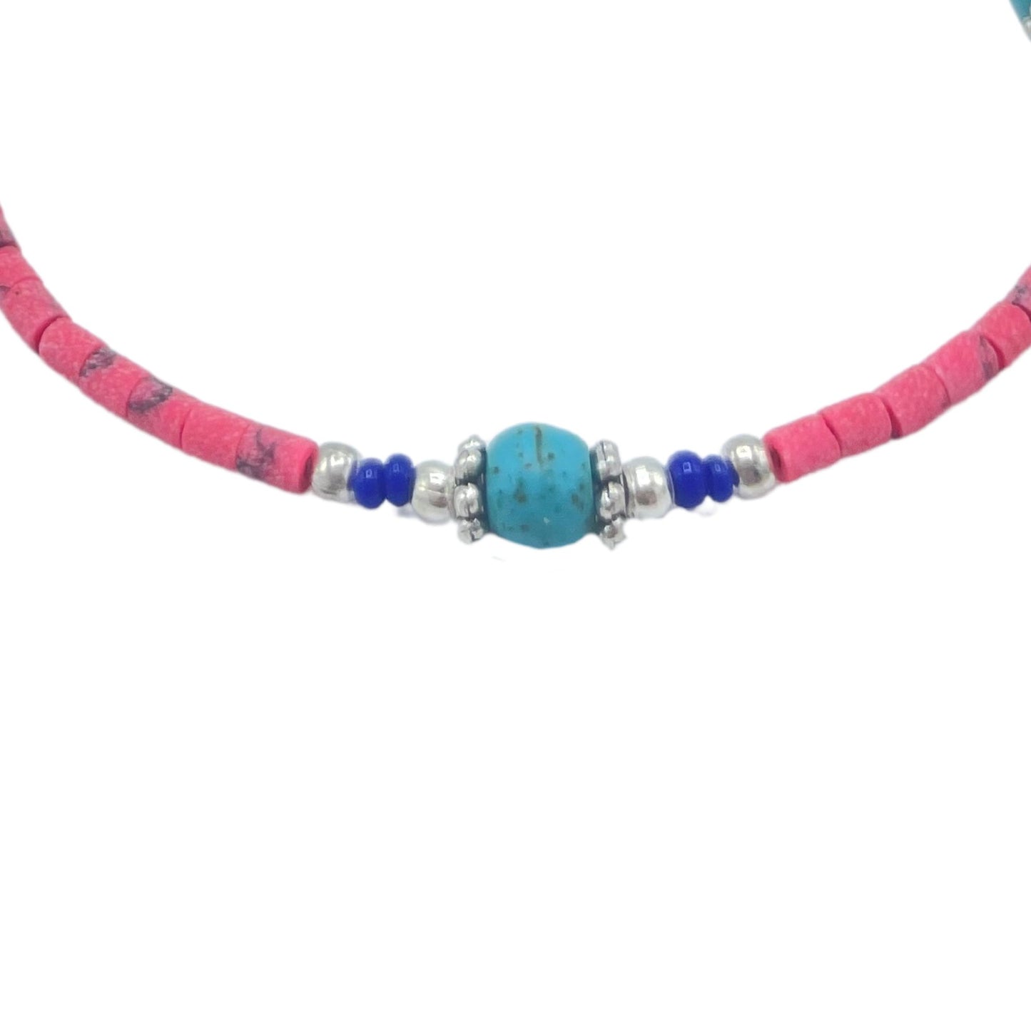 Collar de cuentas en tonos rosa y azul, con detalles de turquesa y metal, estilo bohemio y artesanal.