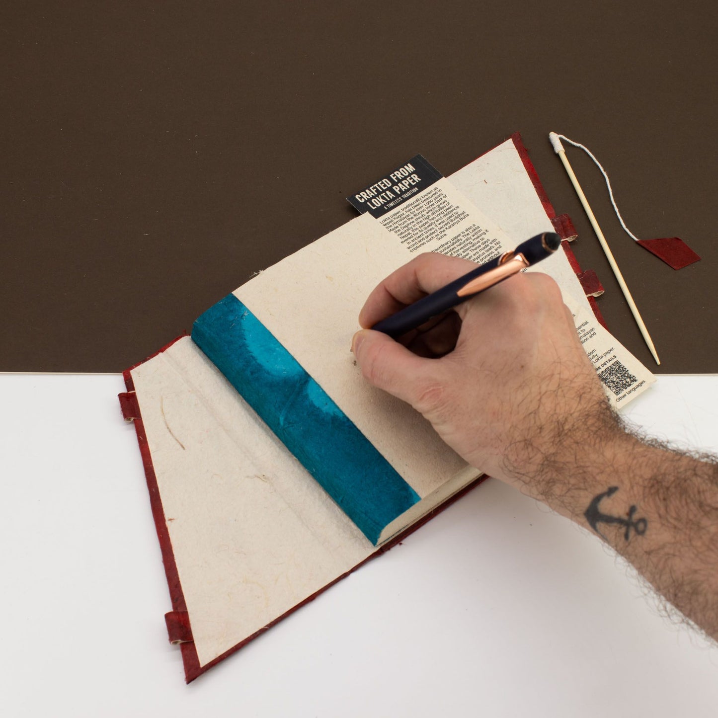 Cuaderno de papel reciclado con tapa azul y rojo, ideal para escribir, con diseño artesanal y detalles únicos.