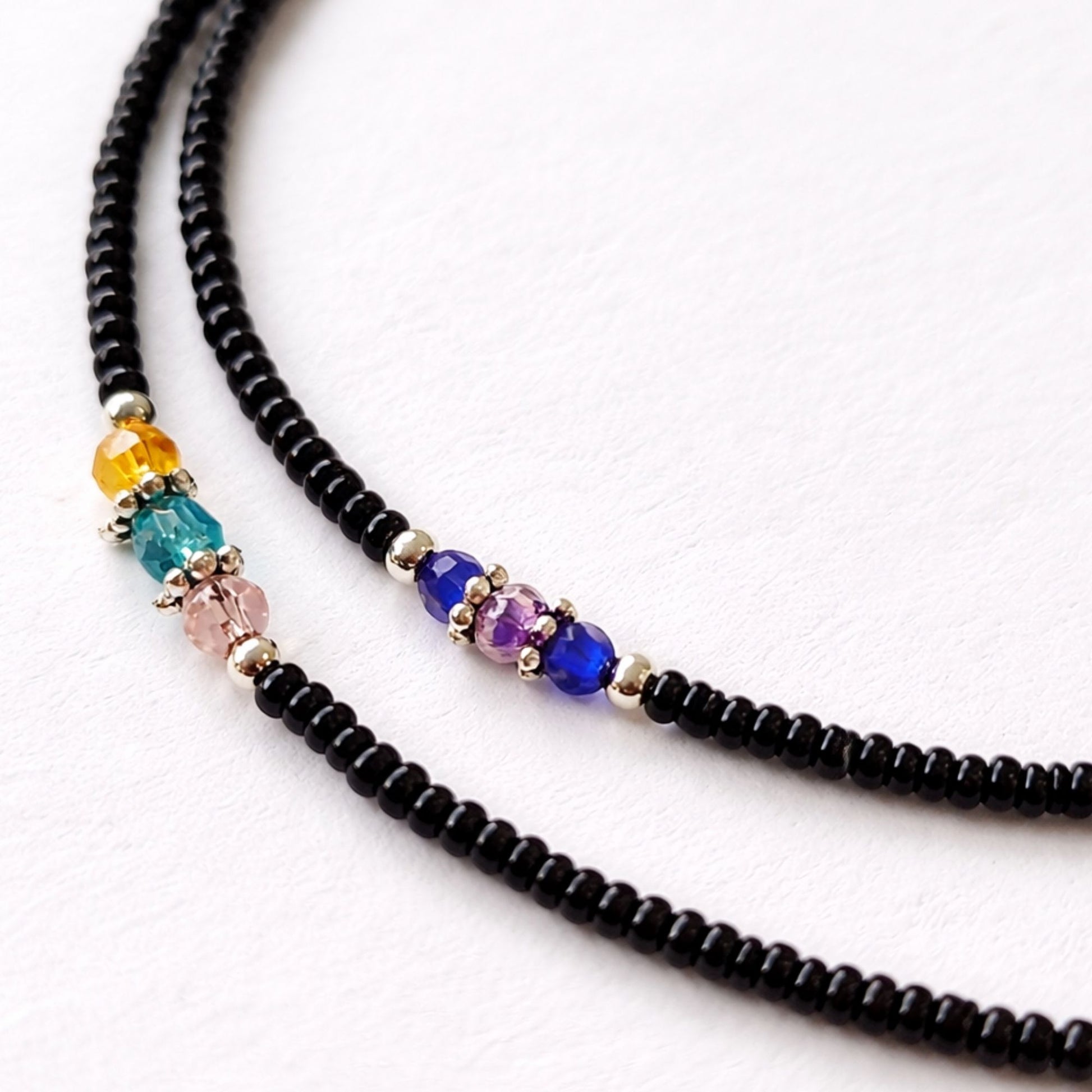 Collar de cuentas negras con adornos de cristal de colores: azul, verde, rosa y amarillo, estilo bohemio.
