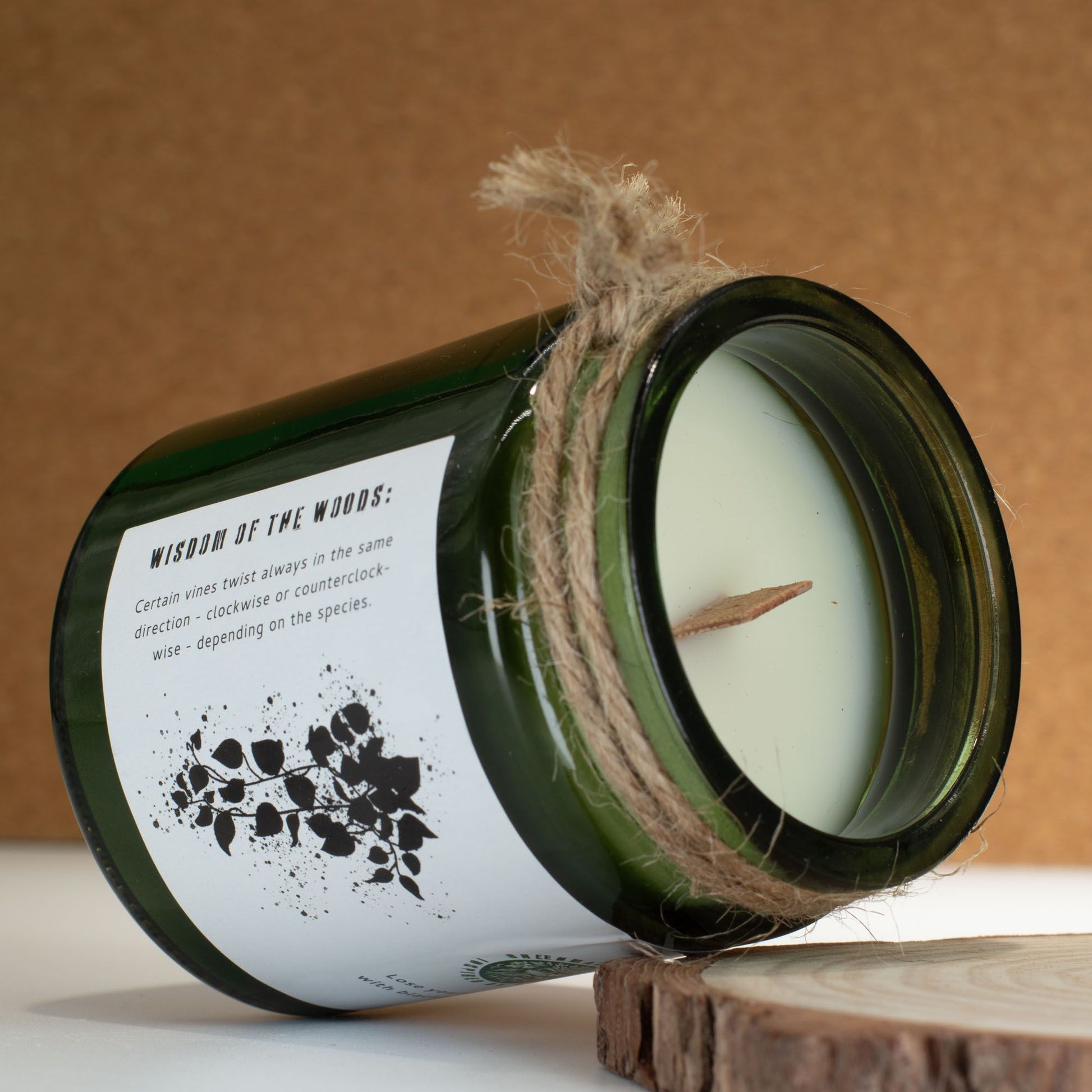 Vela ecológica verde en frasco de vidrio, aroma "Sabiduría del bosque", con mecha de madera y cuerda decorativa.