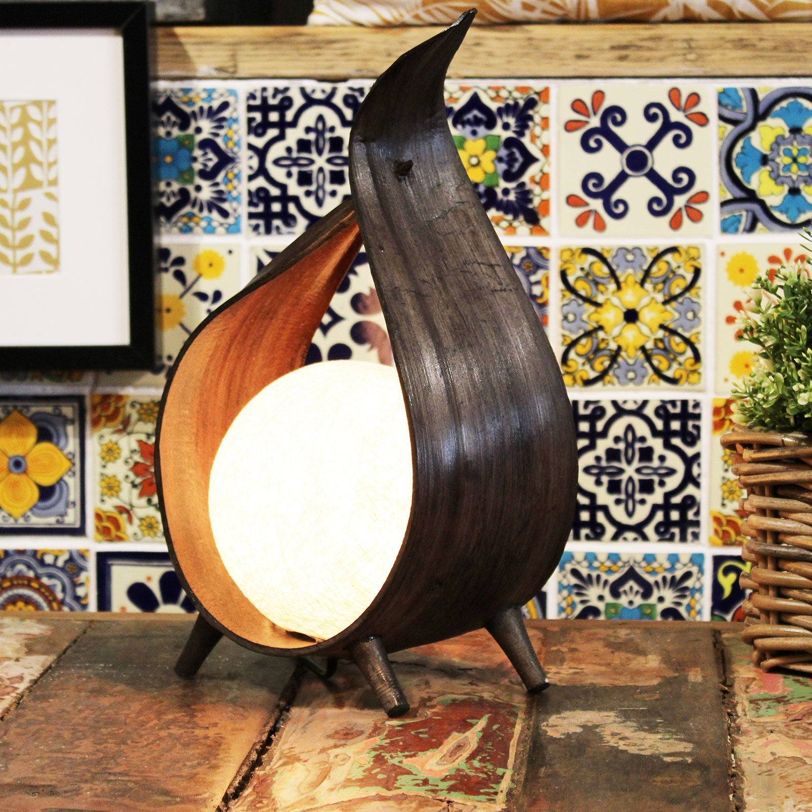 Lámpara de madera oscura en forma de gota con luz cálida, estilo moderno y contemporáneo, fondo de baldosas coloridas.